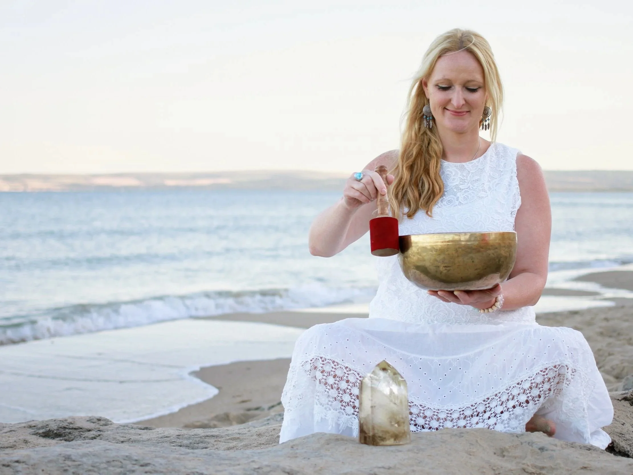 Emma Penman playing the singing bowl on Branksome Chine Beach, Bournemouth captured by Wild Mind Studios