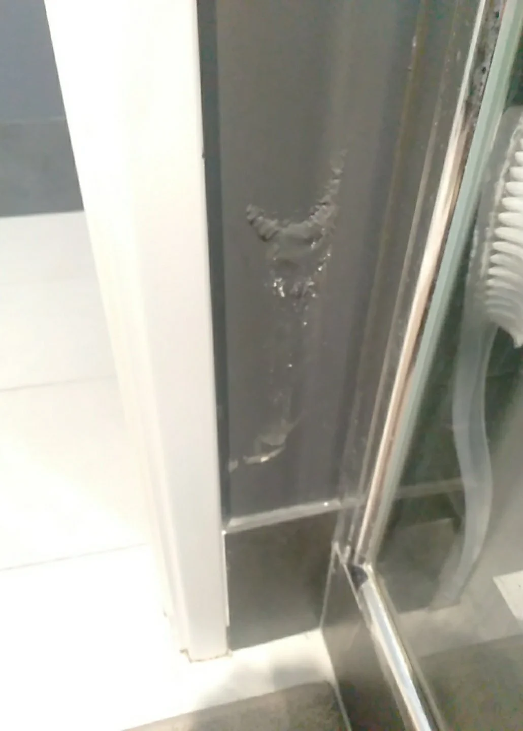 Close-up of a scratched and damaged metal door frame.