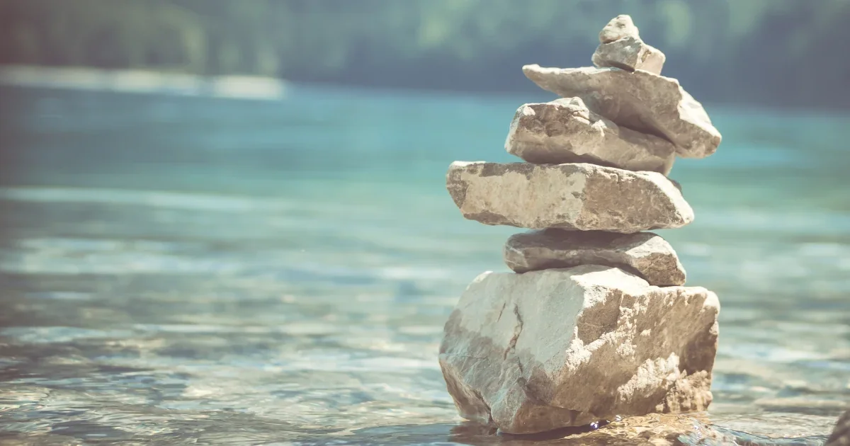 Ausgeglichenheit und innere Ruhe – Steine im Wasser, Symbol für den Grundlagenkurs Meditation