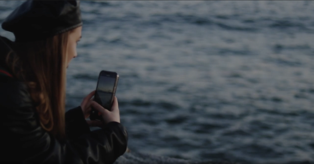 Person taking photo of ocean with smartphone
