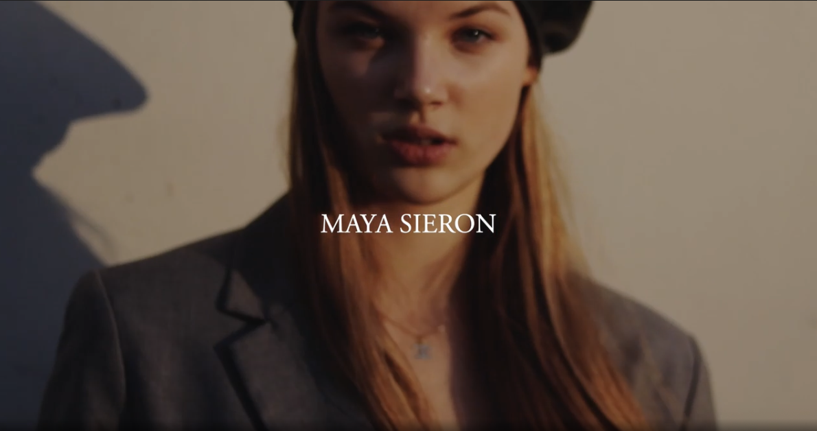 Close-up of a person wearing a beret and blazer with text "Maya Sieron" overlaid.