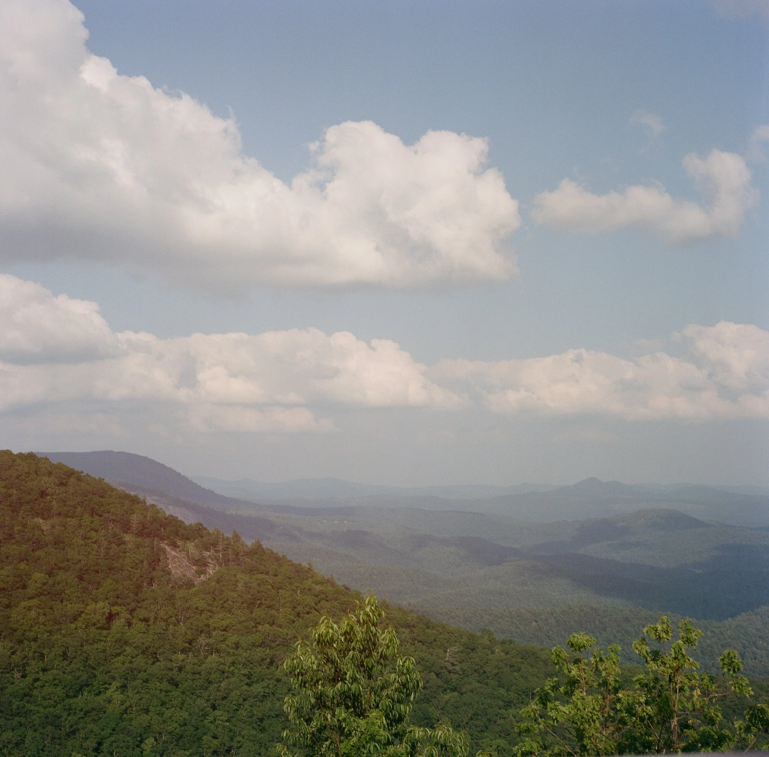 Analog landscape photograph of layered Appalachian mountains beneath a wide summer sky.
