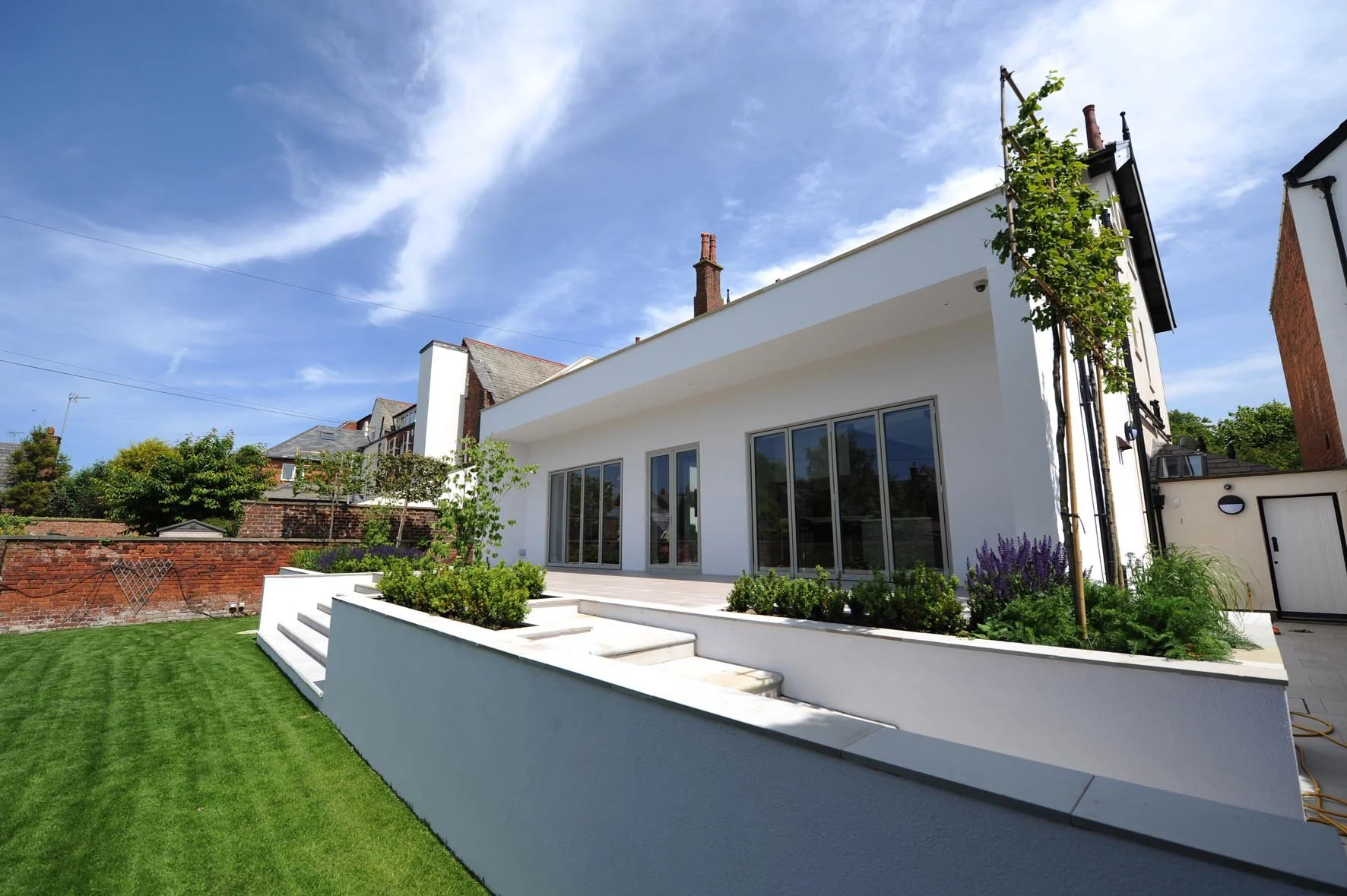 Contemporary Rear Extension — Modern garden-facing extension with expansive glazing, white rendered walls and landscaped terrace.