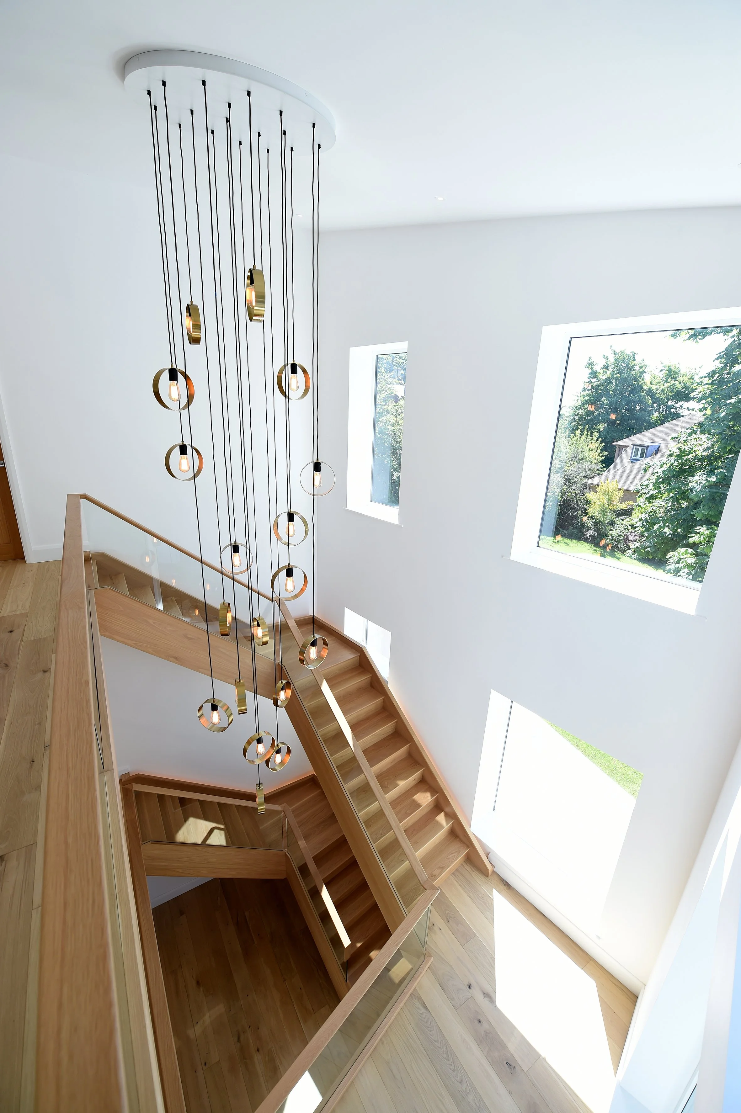 8 Church Drive, Lytham – Contemporary Staircase

Architectural photograph looking down the sculptural timber staircase, featuring a curved balustrade, double-height entrance space, feature pendant lighting and natural light from the surrounding windo