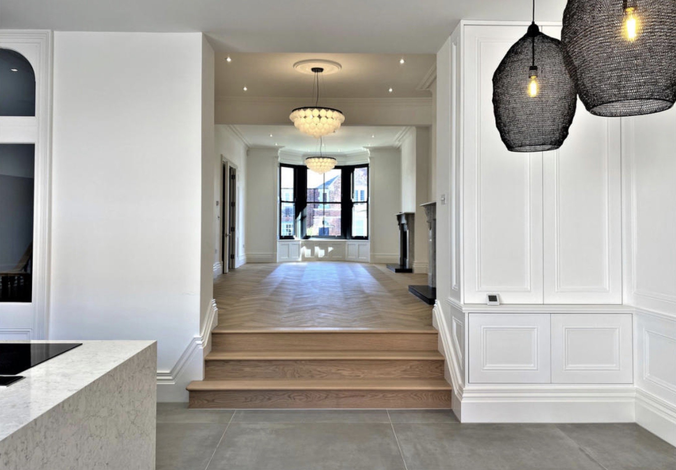 Open-plan interior with subtle level changes, contemporary lighting and garden views.