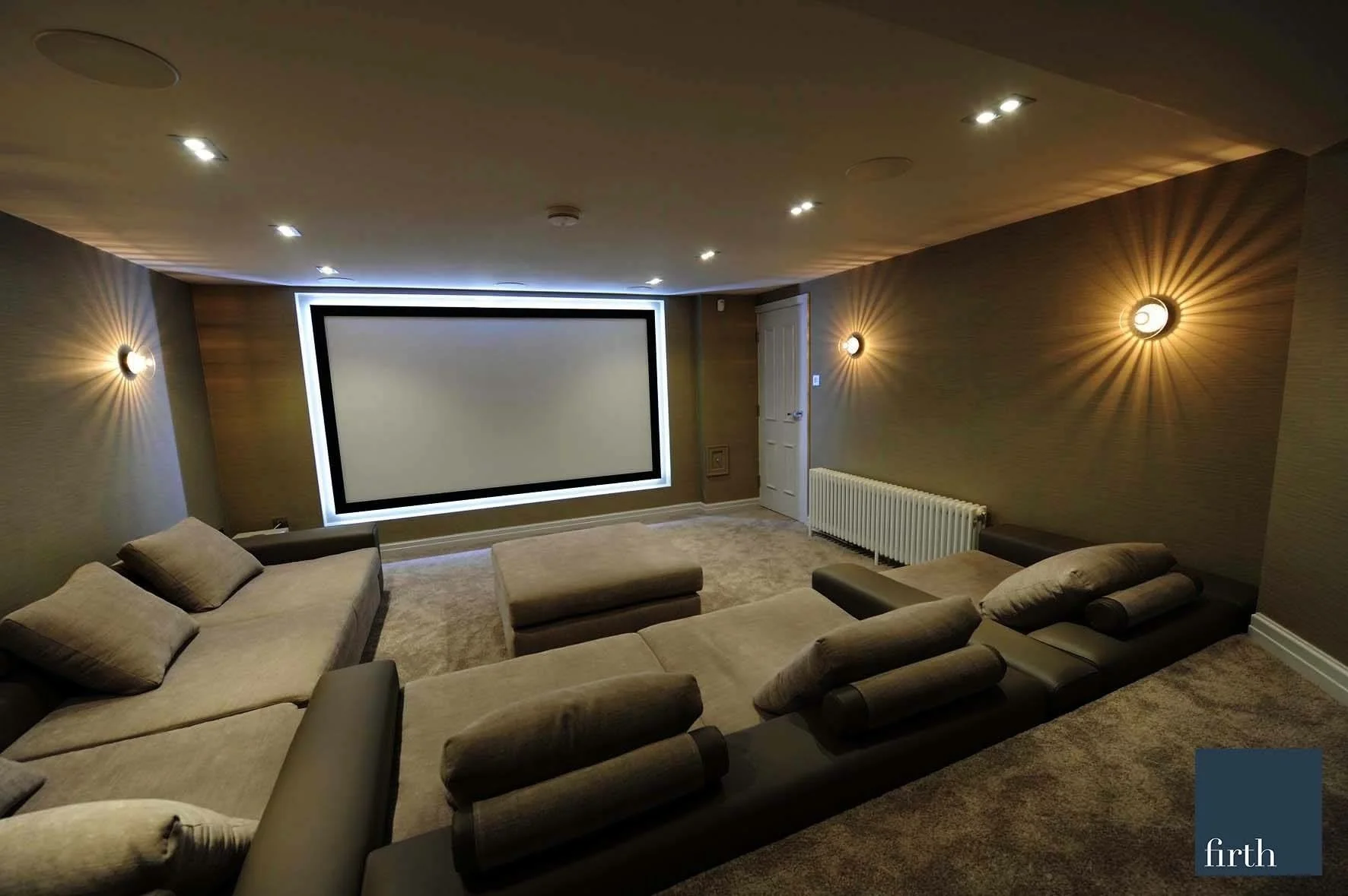 Basement Cinema — Bespoke home cinema featuring tiered seating, large projection screen and integrated lighting.