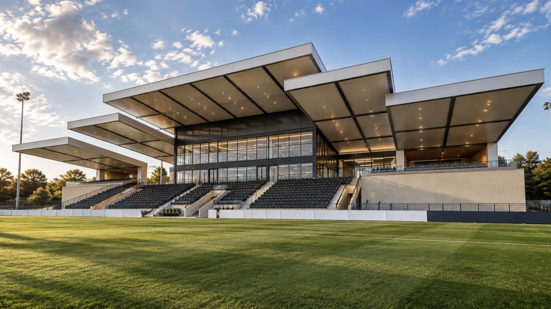 Community Football Stadium — Sports and Hospitality Architecture — contemporary stadium design incorporating covered spectator stands, a central glazed pavilion and a range of hospitality facilities, including bars, restaurants, dining areas and even