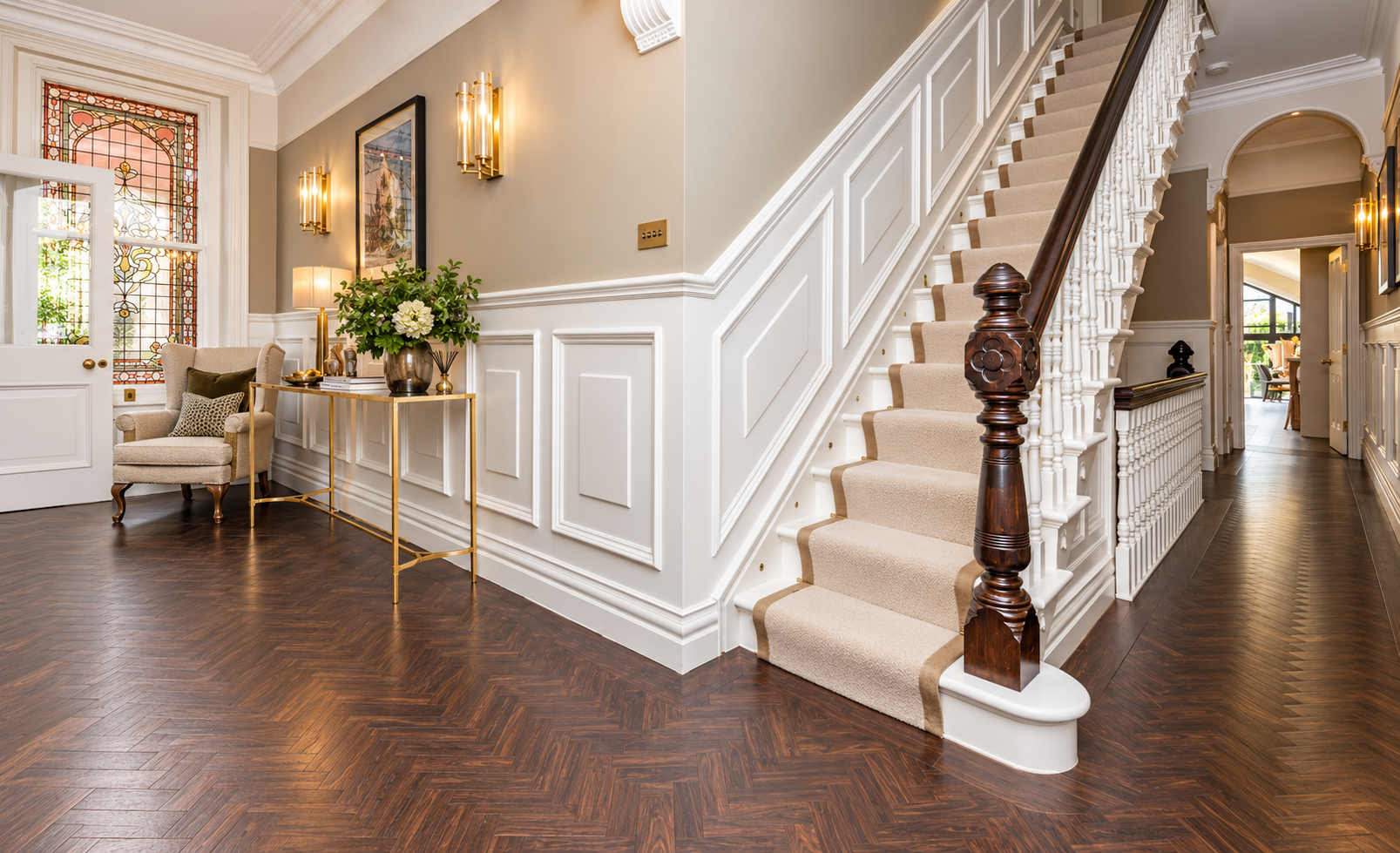 Entrance Hall — Elegant hallway with restored period staircase, decorative wall panelling, dark timber flooring and refined interior detailing.