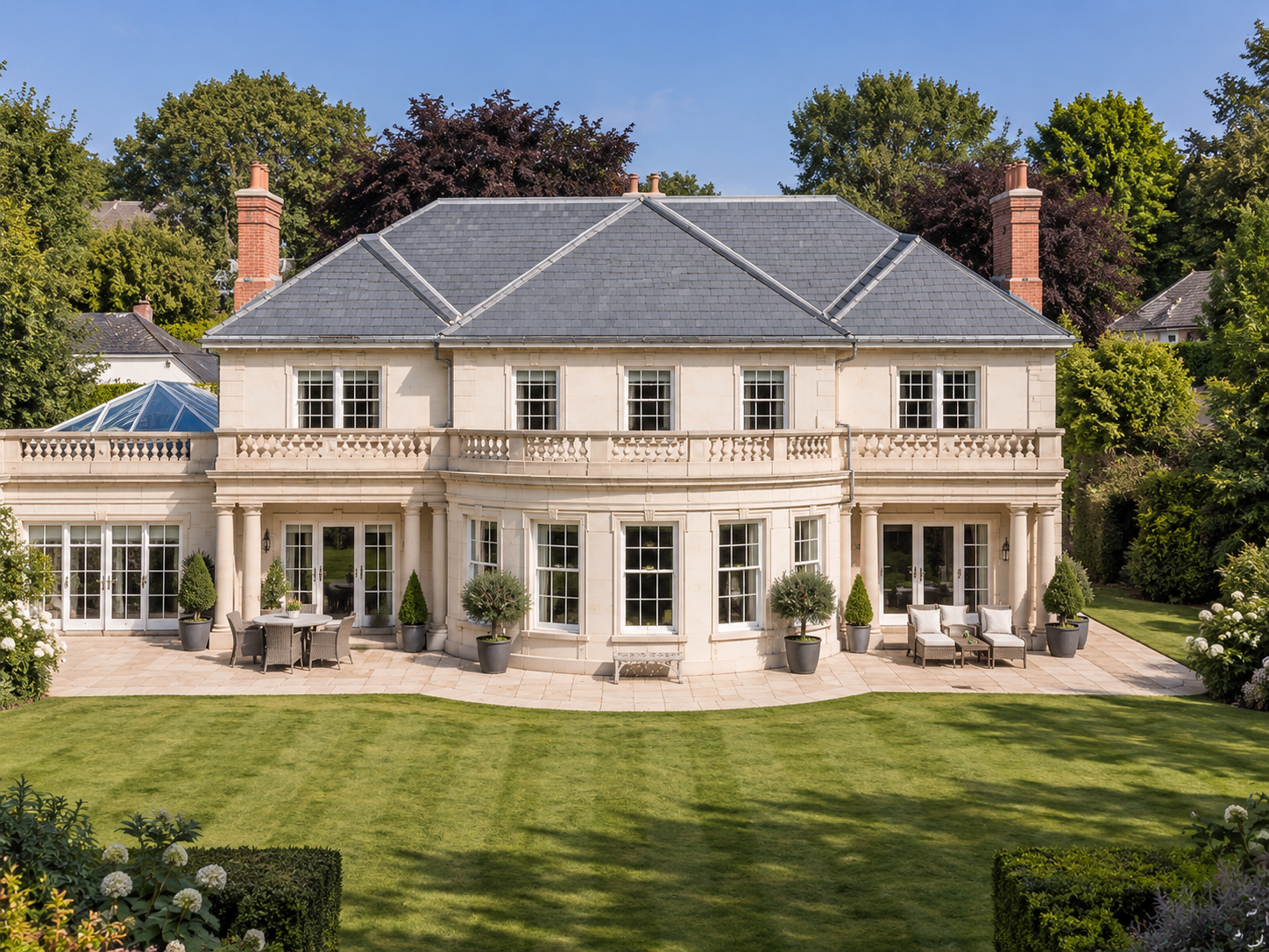 Applegarth, Islay Road, Lytham, Lancashire — elegant rear elevation featuring classical architectural detailing, curved bay windows, stone balustrades, a glazed garden room and expansive landscaped gardens.