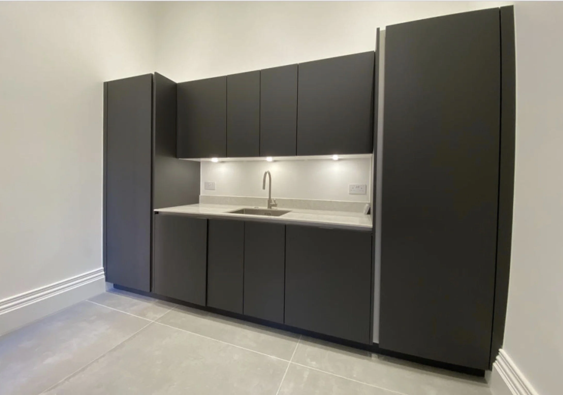  Contemporary fitted pantry with integrated appliances and contrasting cabinetry.