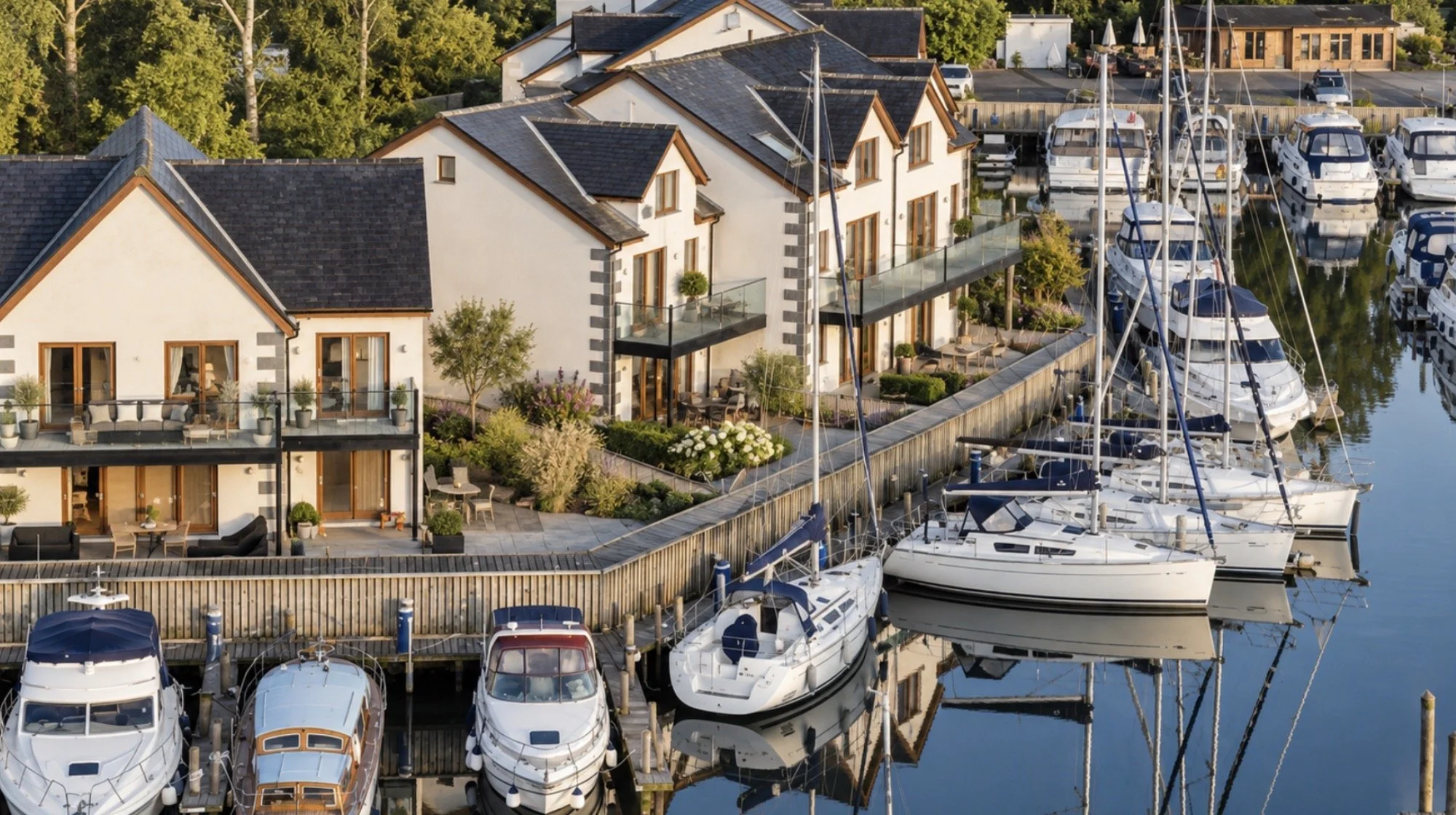 Windermere Marina Village, Lake District, Cumbria — waterfront view of traditional timber-framed houses and apartments designed by Joel Firth between 2003 and 2005, featuring pitched roofs, private balconies and direct views across the marina and its