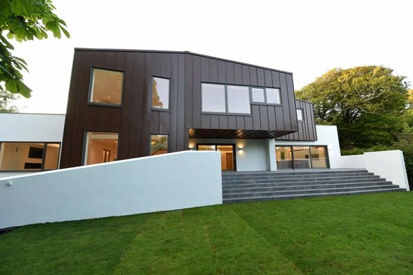 8 Church Drive, Lytham – Sculptural Zinc Form

Architectural photograph from the front garden highlighting the sculptural zinc-clad form cantilevered over the terrace, creating a striking contemporary composition of curved surfaces and expansive glaz