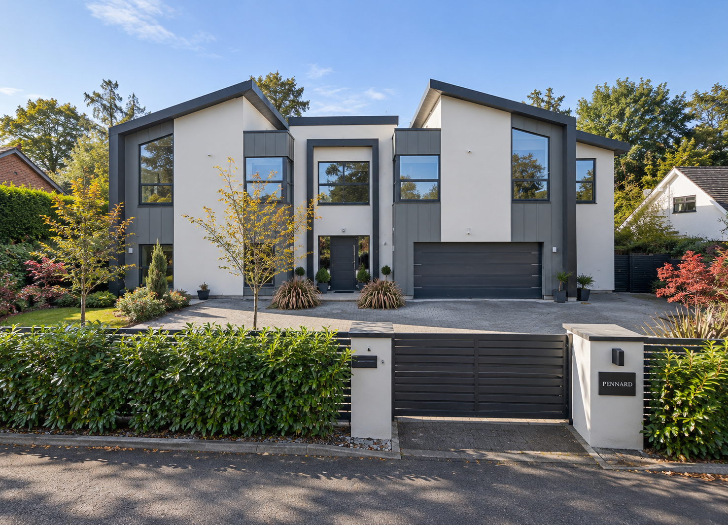 Pennard, Islay Road, Lytham, Lancashire — contemporary luxury residence featuring striking asymmetric gables, contrasting white render and dark cladding, expansive glazing, integrated double garage and landscaped gated entrance.
