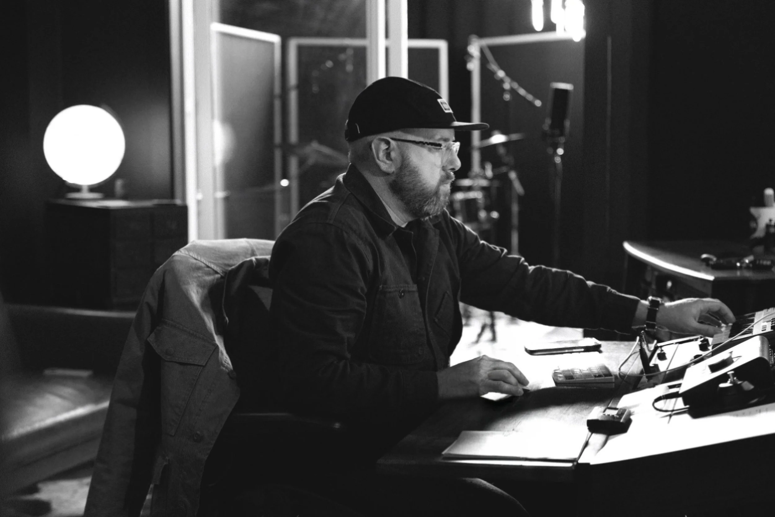 Music Producer and Mixing Engineer sits at his desk and makes adjustment to a song.