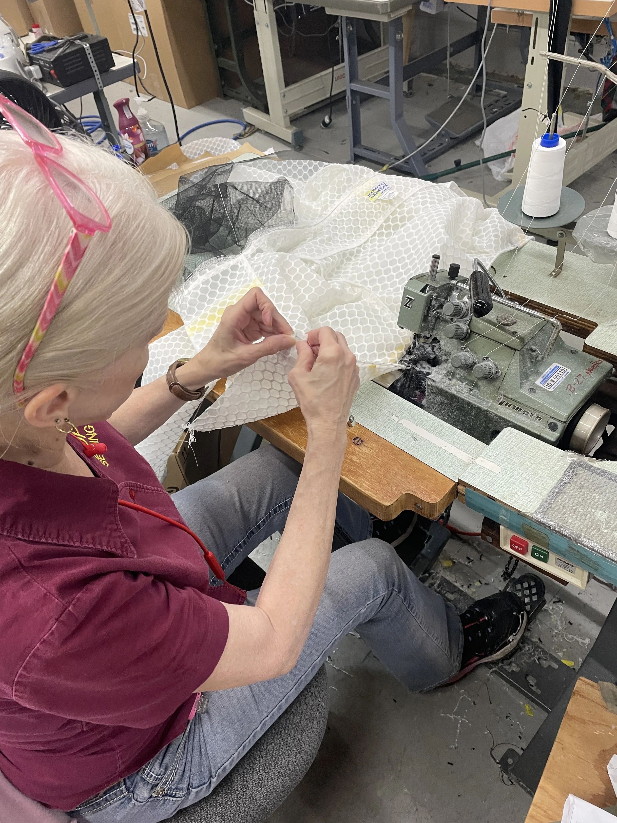 Manufacturing team member sewing a Jeometry Sunny Suit