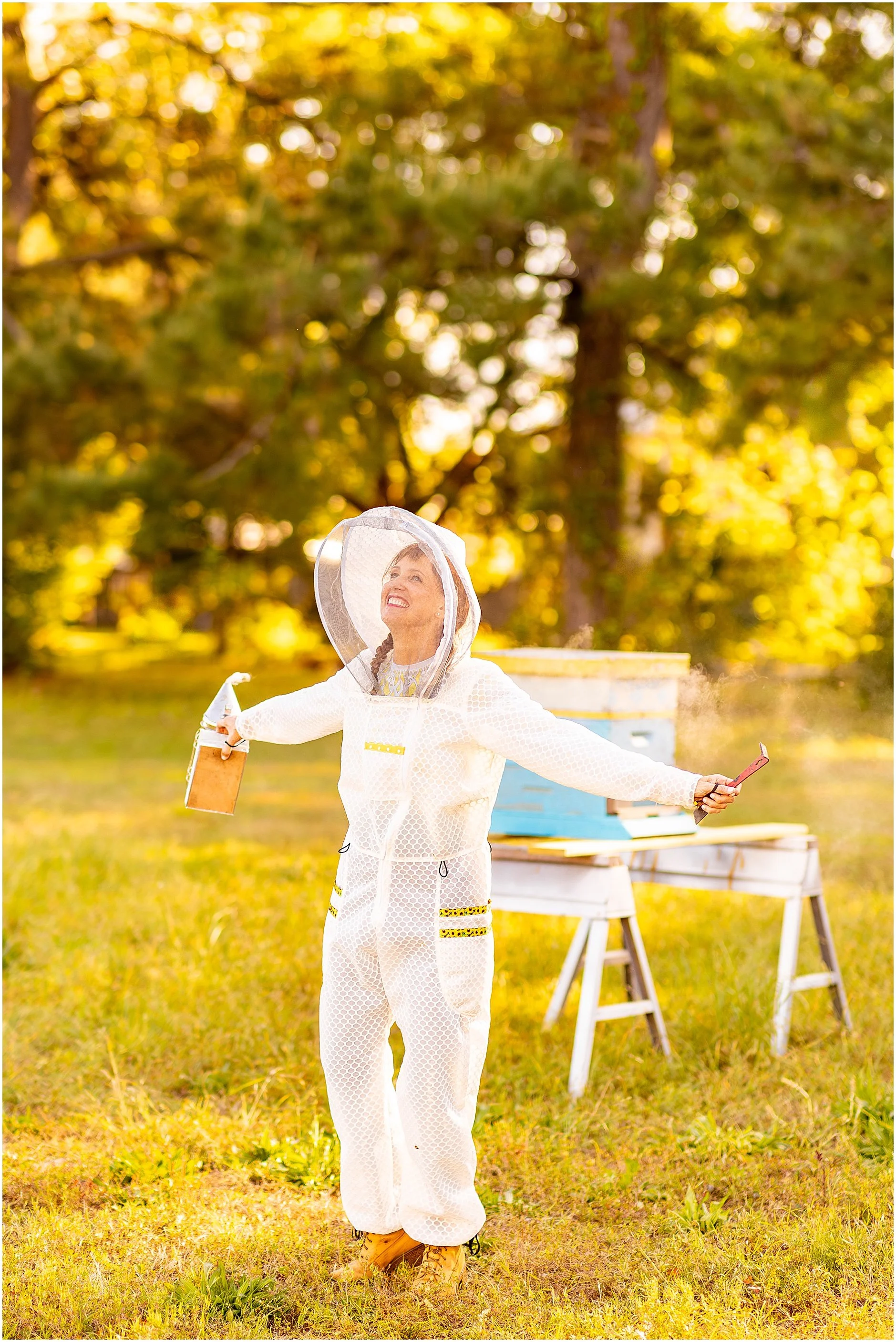 Female beekeeper, Jenna York, embracing as she wears the Sunny Suit from Jeometry Beewear™ in her apiary on Folly Beach