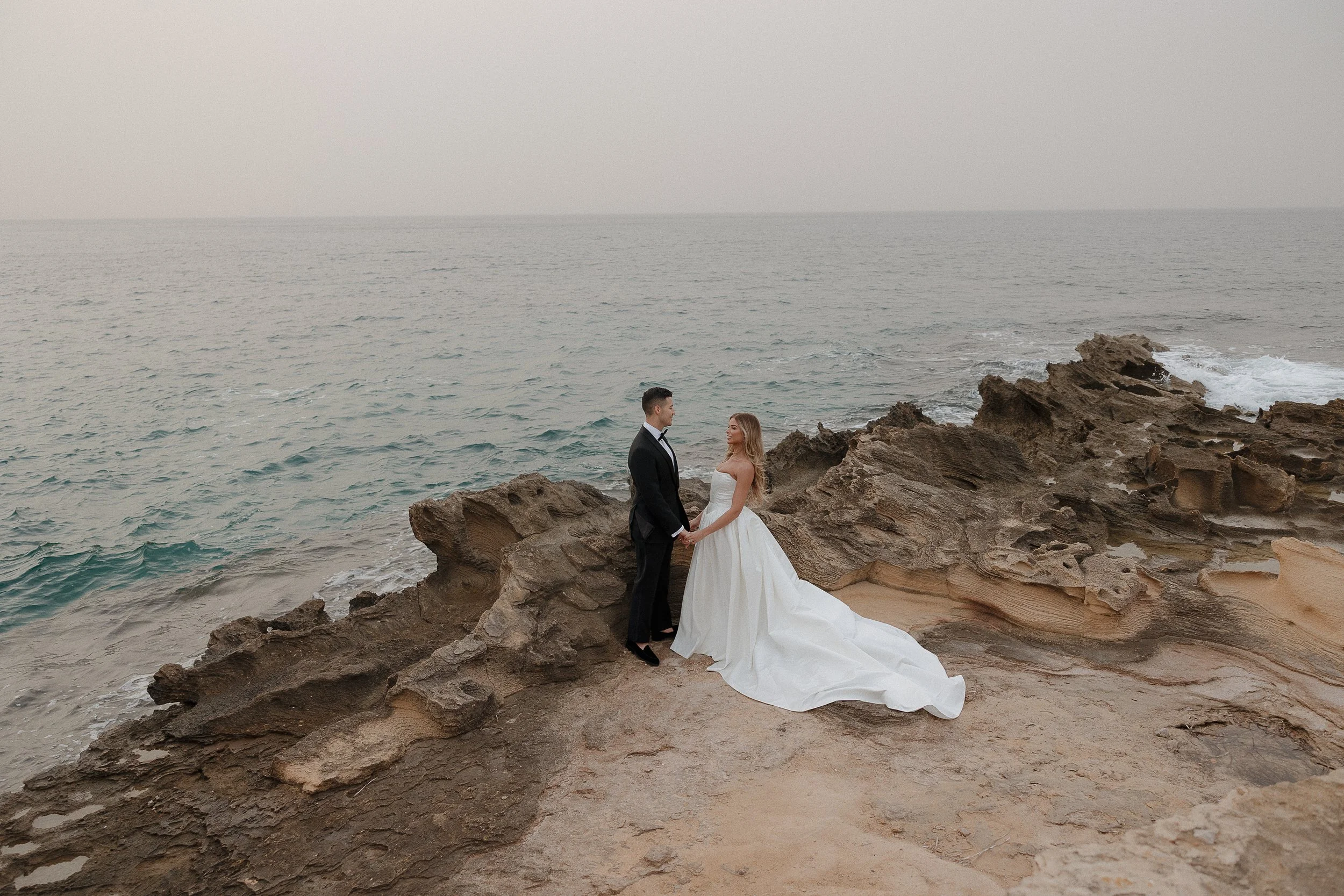 The couple framed by cliffs and ocean — a signature Mallorca elopement look.