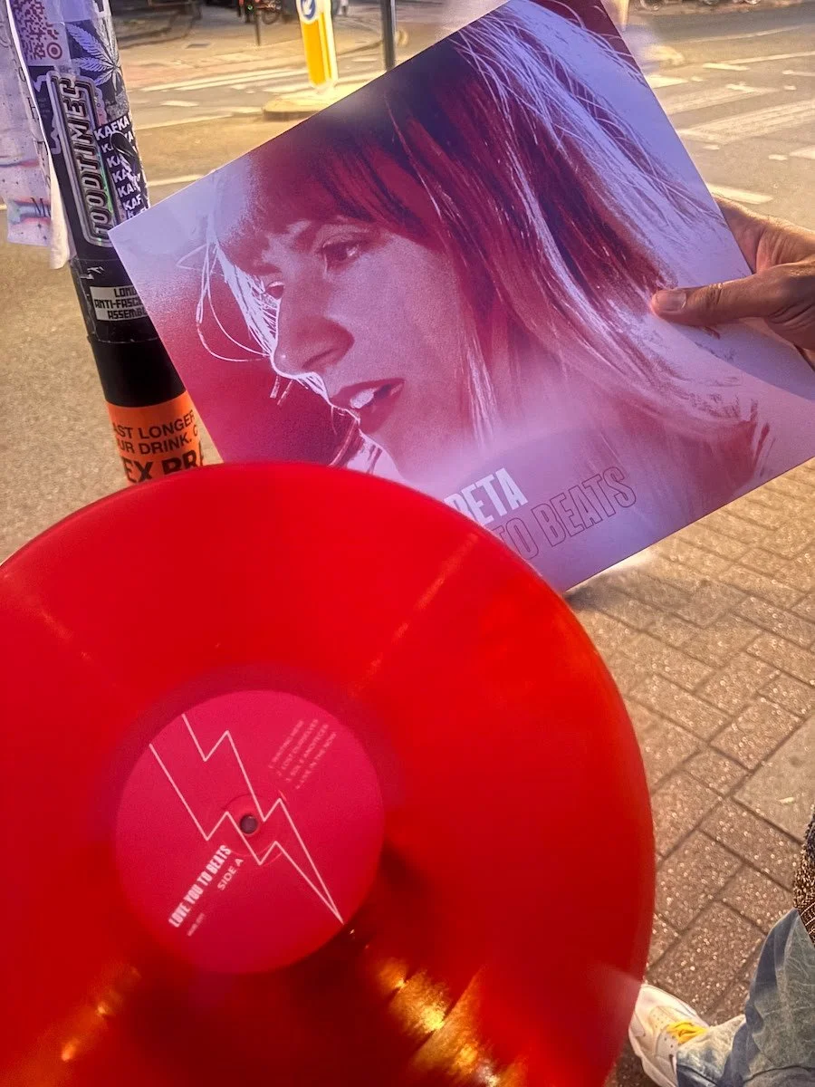 WUNDER BETA vinyl and a person holding it. A red vinyl with white text and graphics of her lightning bolt motif.