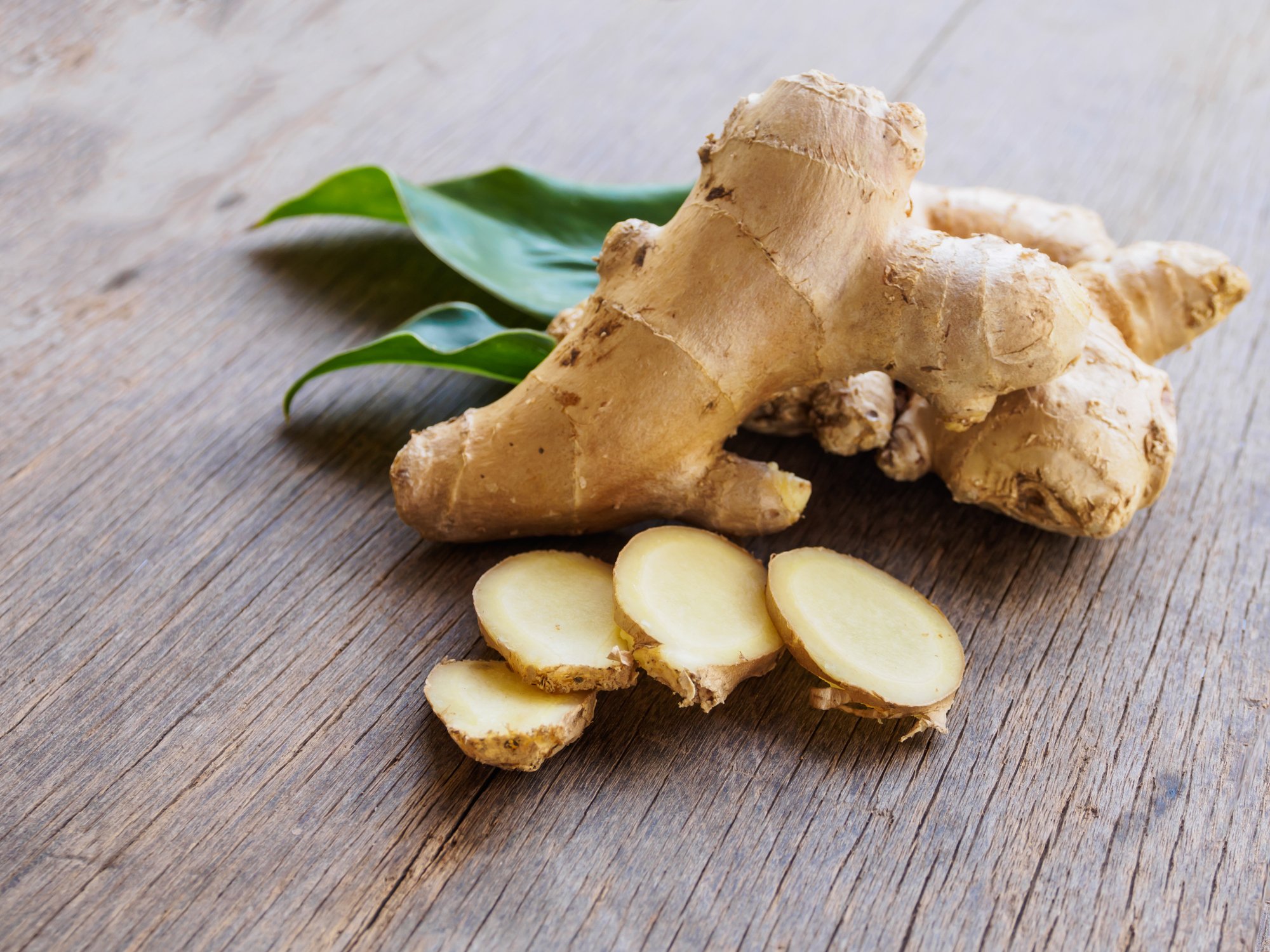 Fresh Ginger half sliced on a wooden table