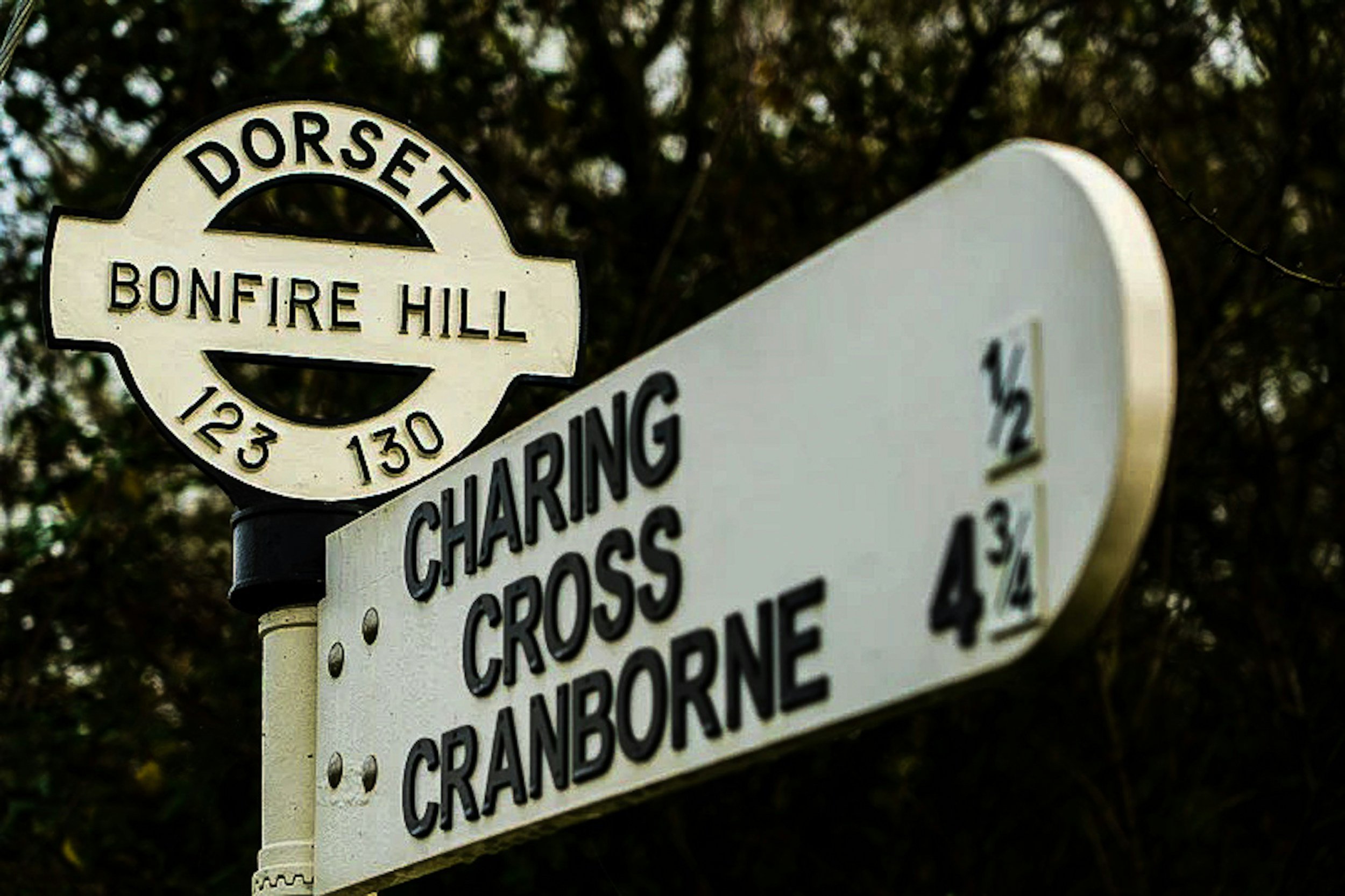 Street sign for Dorset Bonfire Hill and Charing Cross Cranborne showing distances to each location.