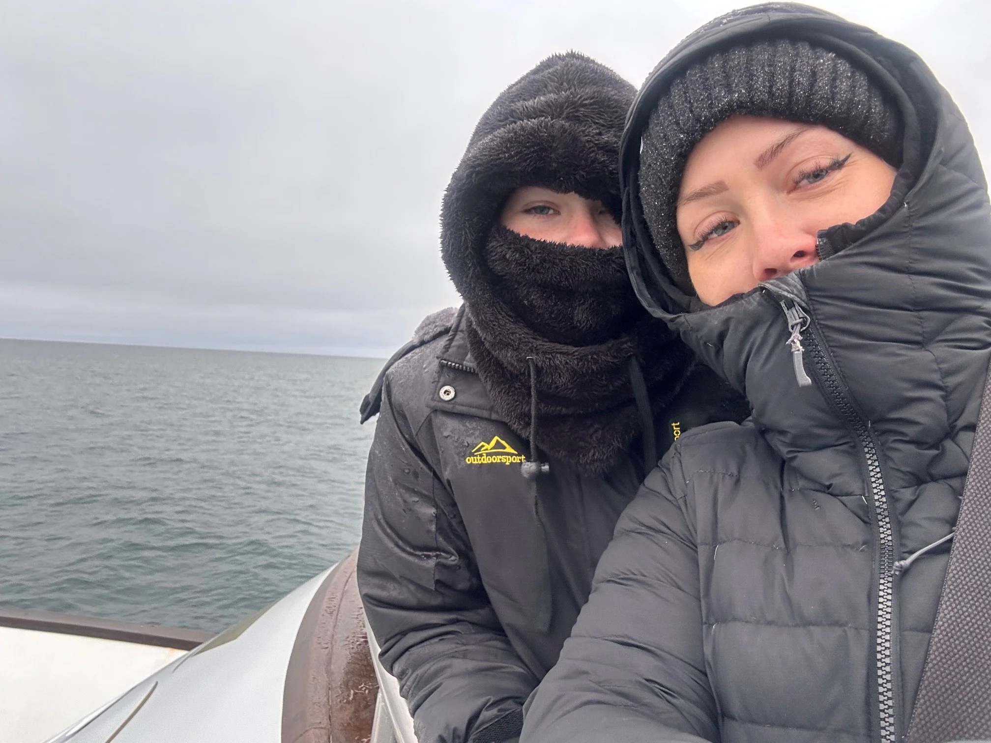 Owner of website and daughter on a whale watching boat. Icelandic coast and sea behind them.