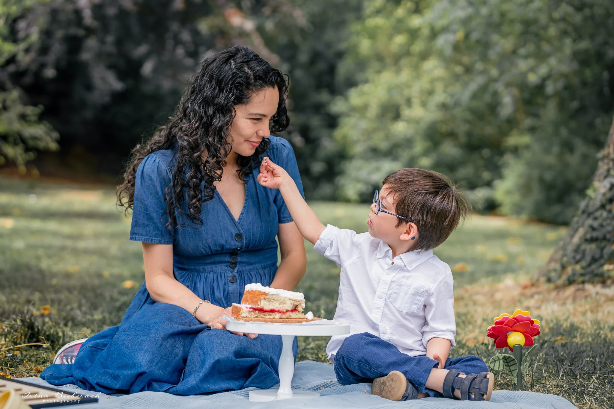 Petit garçon donne un morceau de gâteau à sa maman dans un parc à Saint Germain en Laye