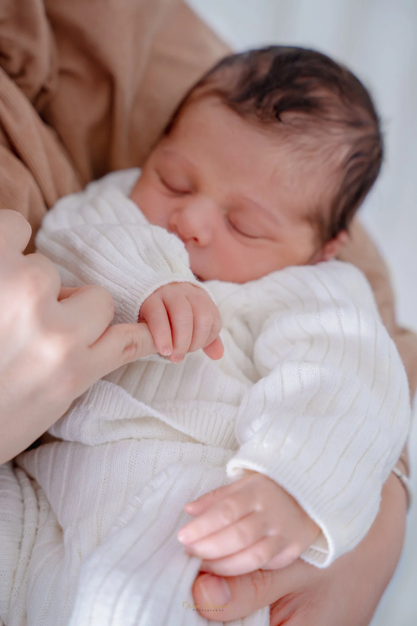 Bébé garçon prend le doigt de sa mère dans sa main
