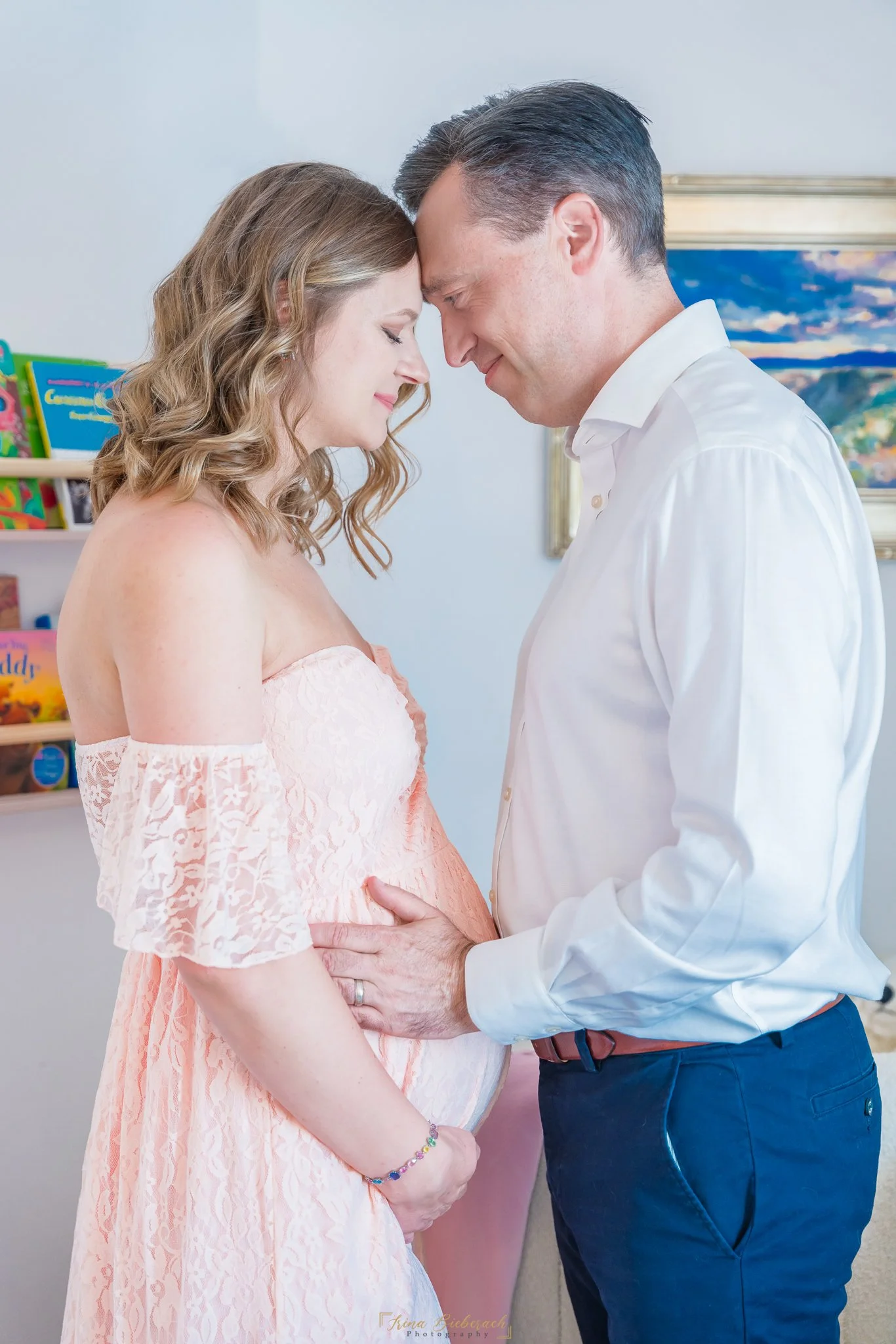 Femme enceinte et som époux reposent ses fronts l'un contre l'autre dans une chambre