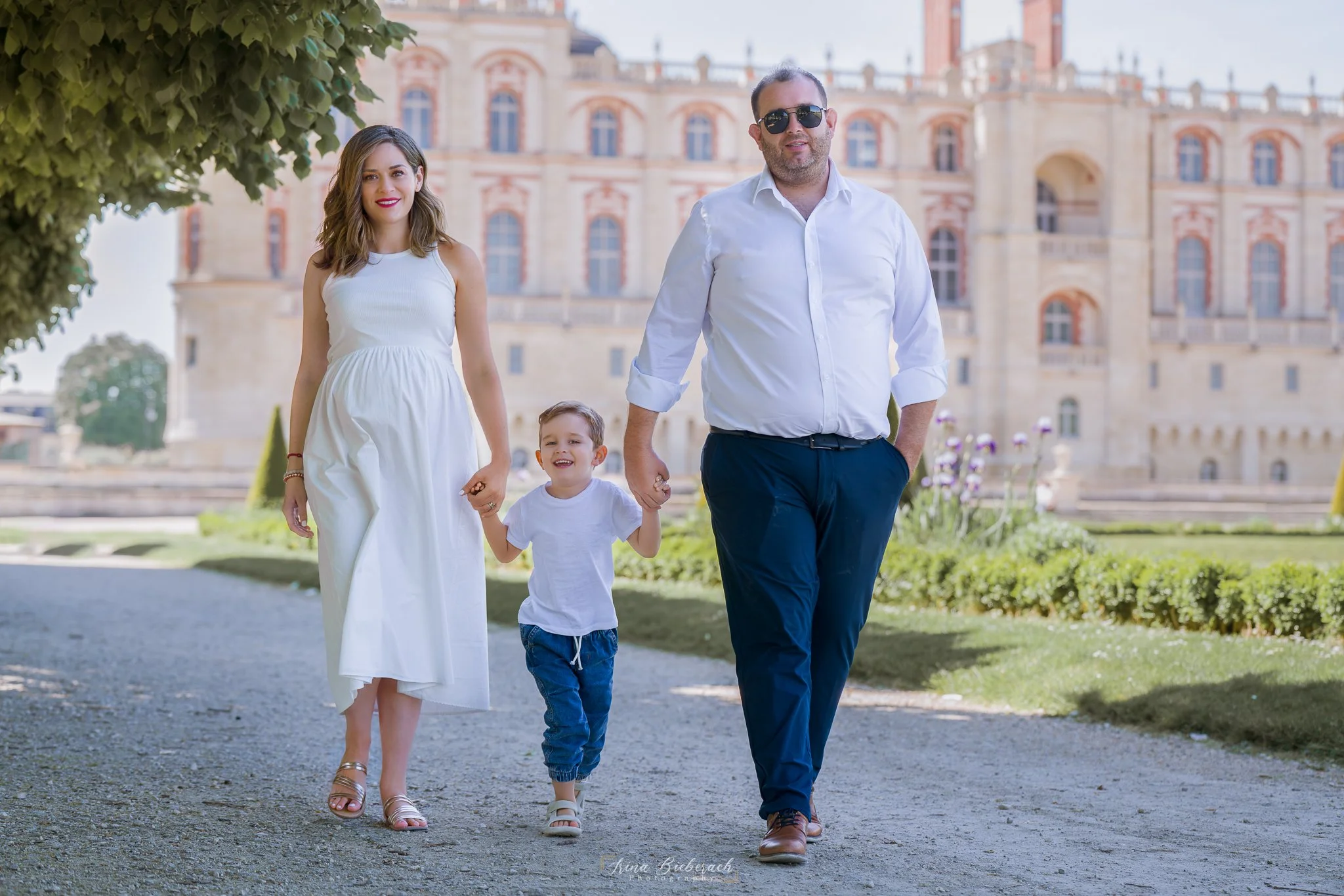 Famille de femme enceinte; garçon et son mari élégamment habillés  se promène dans les jardins du château de Saint Germain en Laye