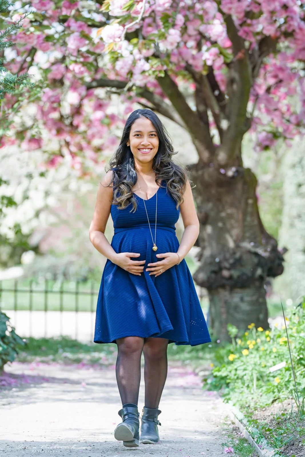 Femme enceinte se promène dans une allée fleurie du Jardin de Plantes