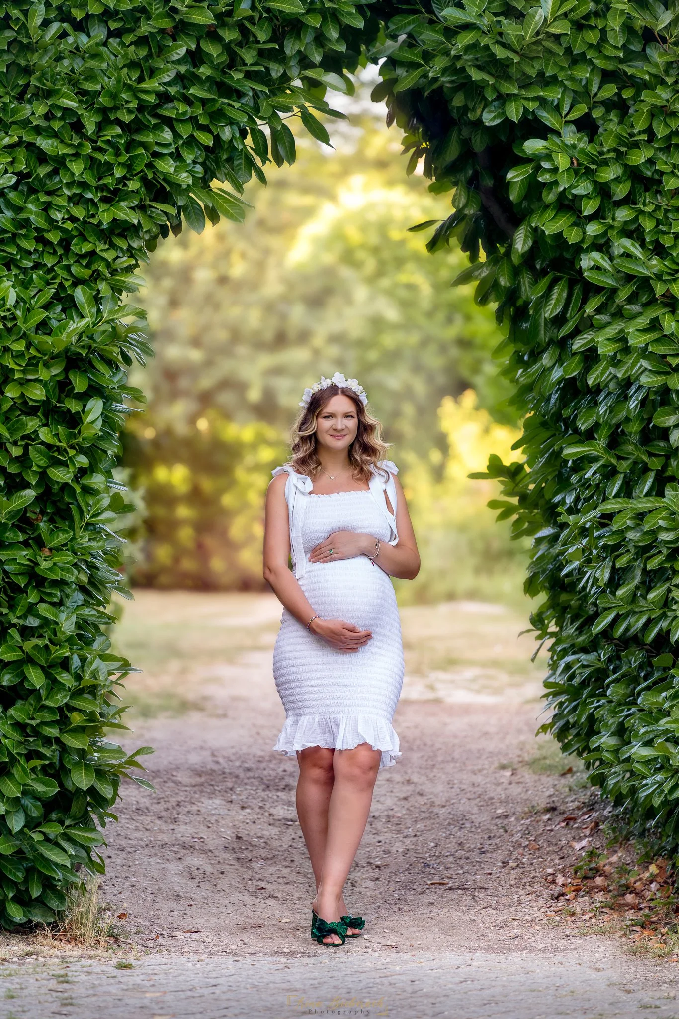 Future maman touche son ventre ronde dans les allées du parc de l île Saint Germain