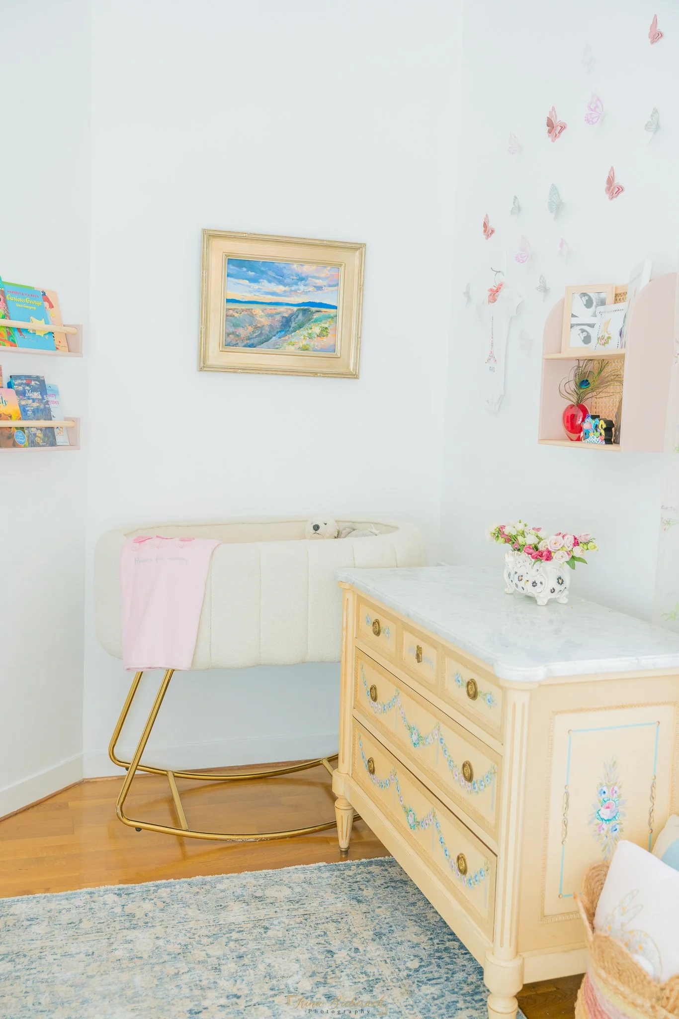 Chambre de bébé avec lit blanc et commode en bois claire baignée par la lumière naturelle
