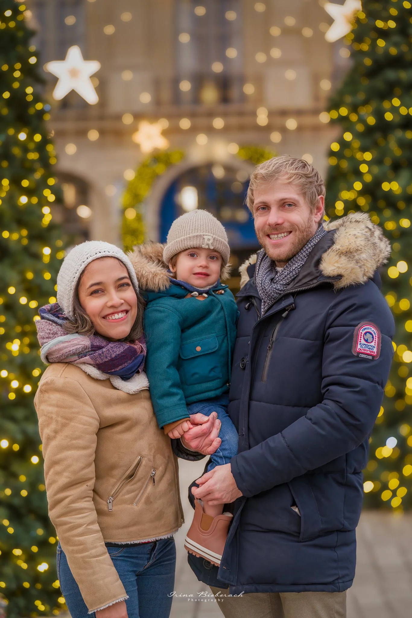 Famille pose devant les sapins de Noël illuminés dans la Place Vendôme