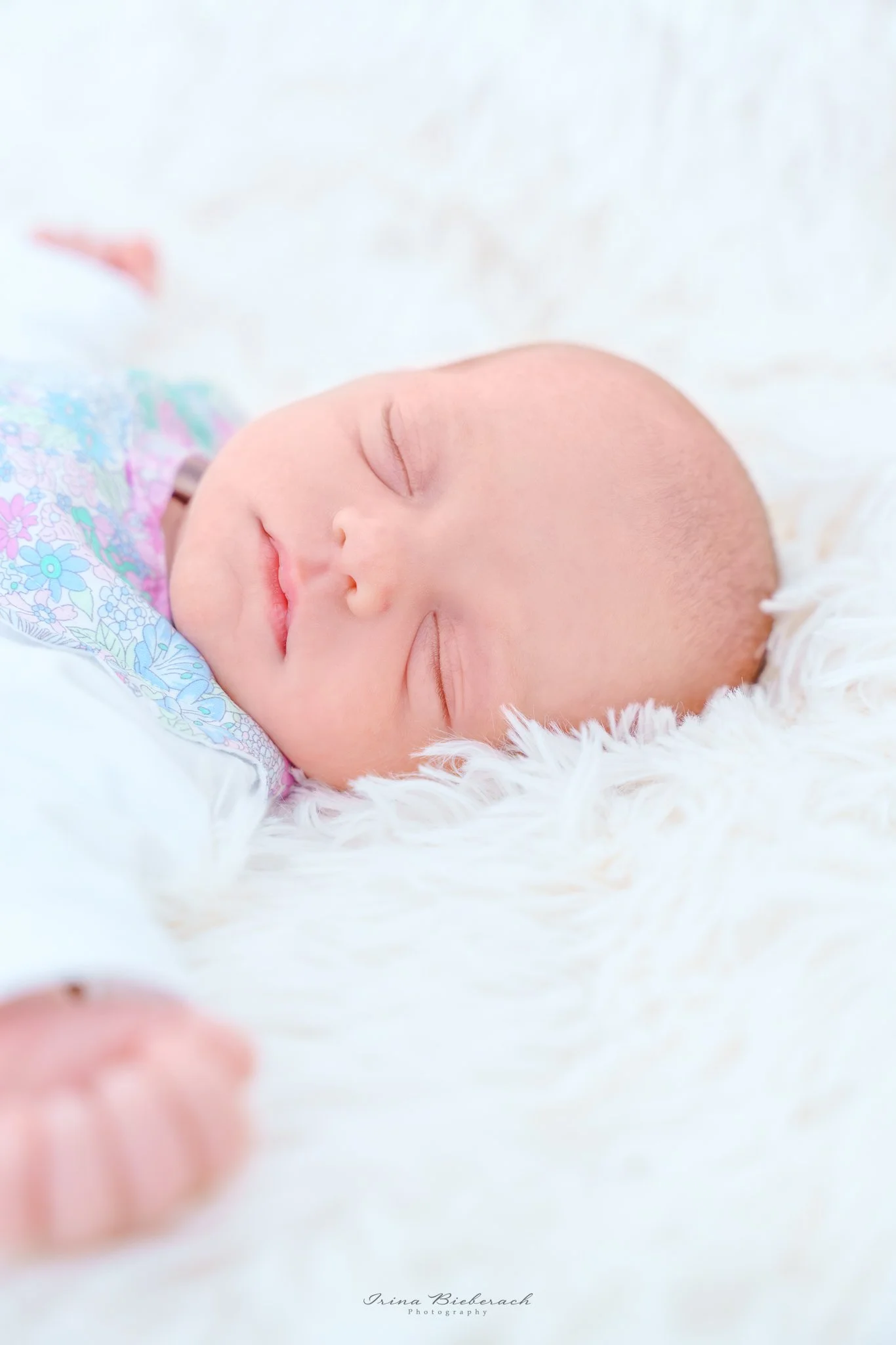 Fille nouveau-né dors sur une couverture douce blanche baignée par la lumière naturelle 