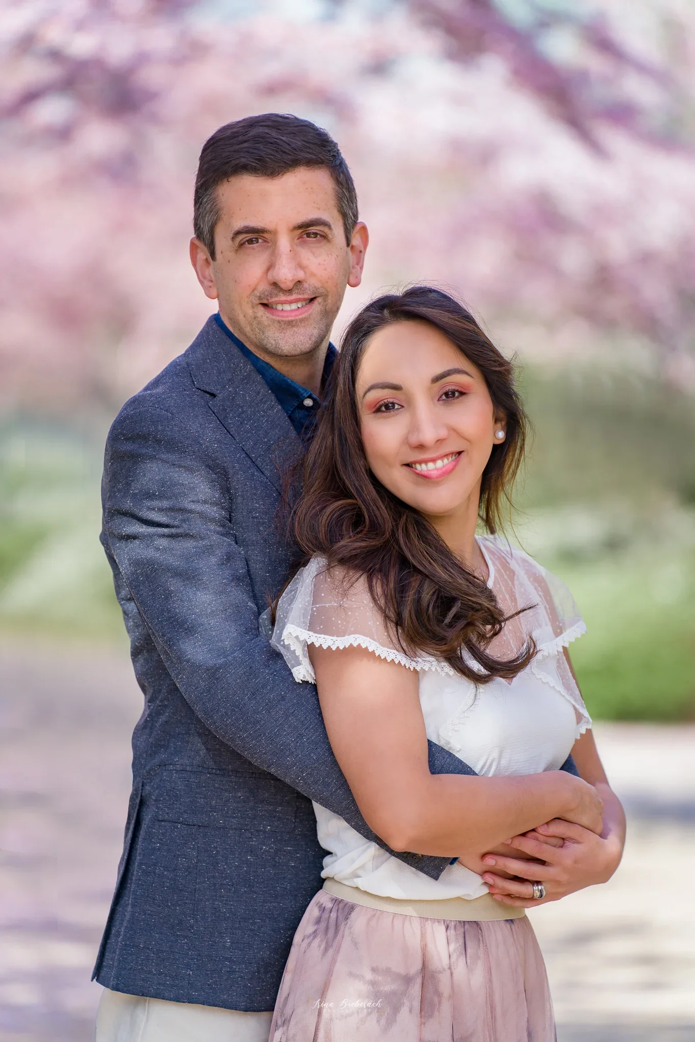Portrait de couple lumineux sous les cerisiers en fleurs, photographe Boulogne-Billancourt lumière du matin.