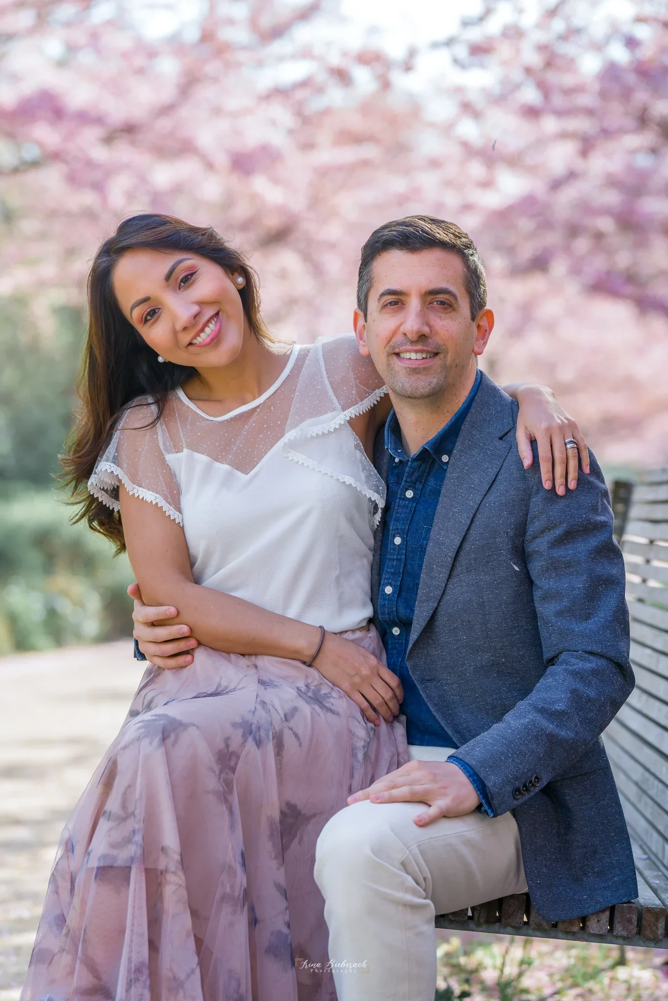 Portrait de couple assis sur un banc en bois au Parc de Billancourt sous les cerisiers près de Boulogne.