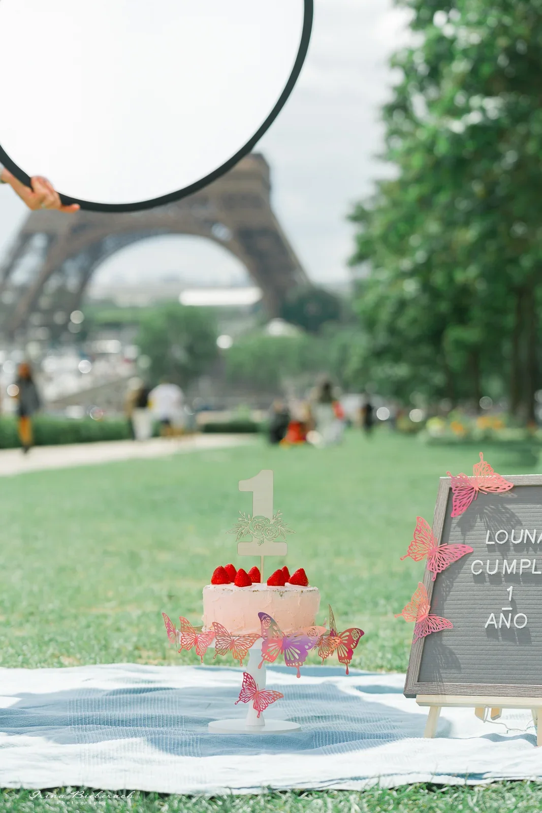 Utilisation d'un réflecteur de lumière pour une séance photo Smash the Cake en extérieur à midi au Trocadéro face à la Tour Eiffel.