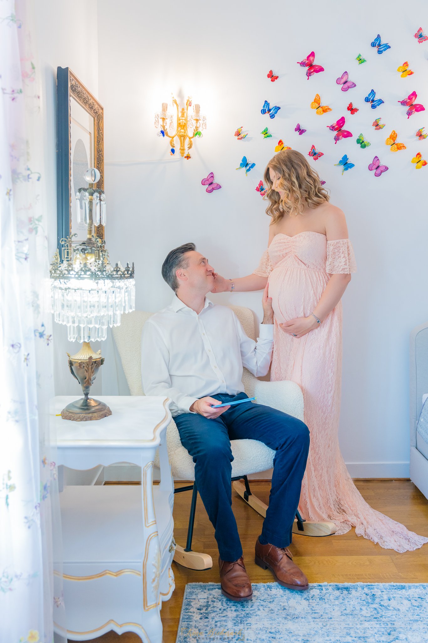 Un couple de futurs parents ont de gestes tendres dans une chambre blanche lumineuse