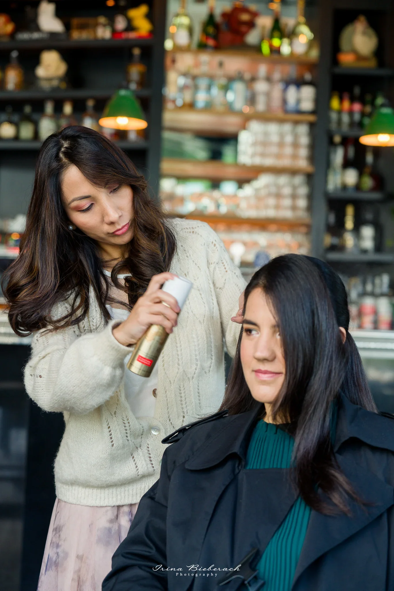 Coiffeuse pro applique de la laque sur les cheveux longs d'une femme
