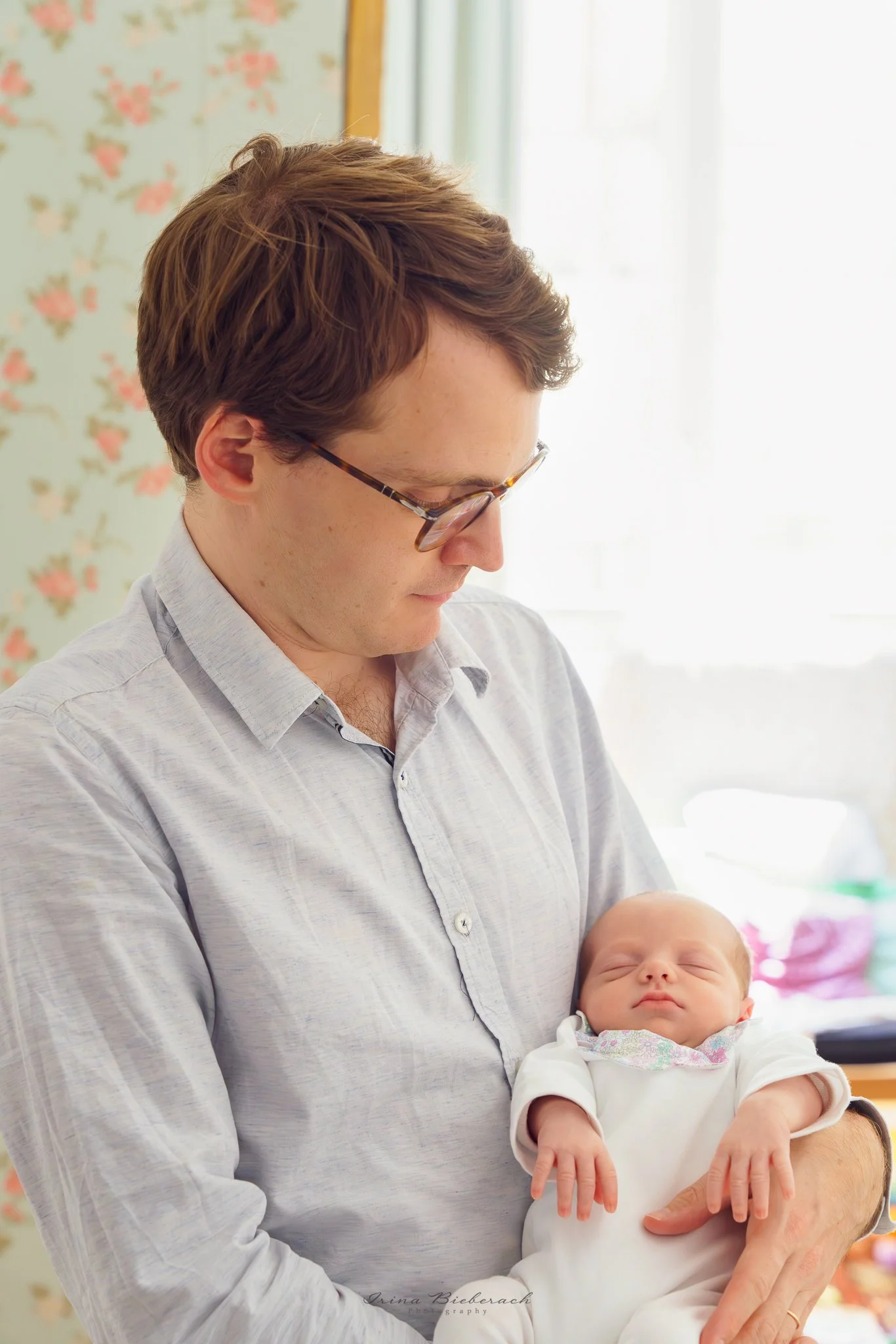 Homme regarde sa nouvelle fille qui dort dans ses bras dans la chambre