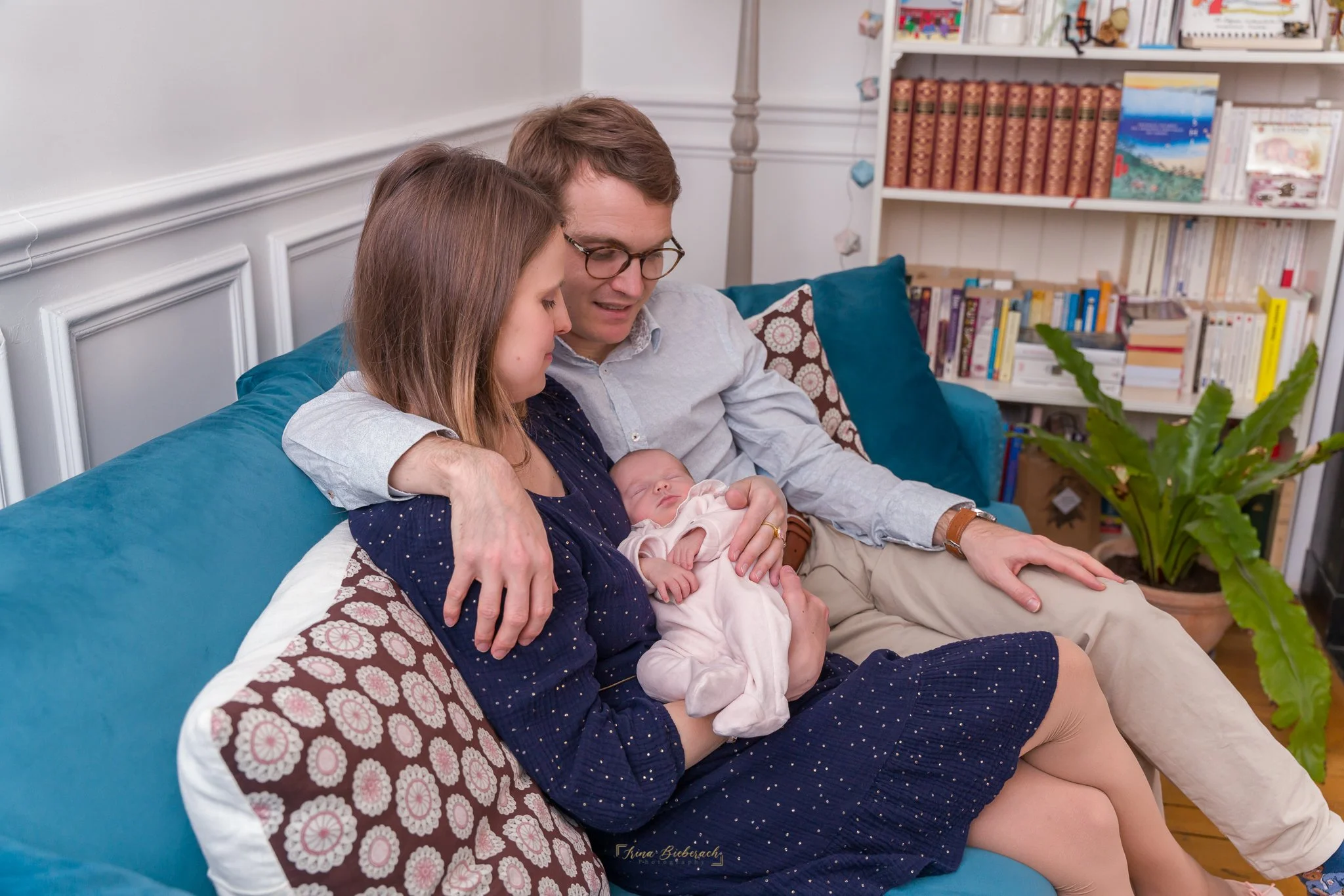 Couple de jeunes parents dans leur salon d’appartement à Paris regardent leur bébé dormir