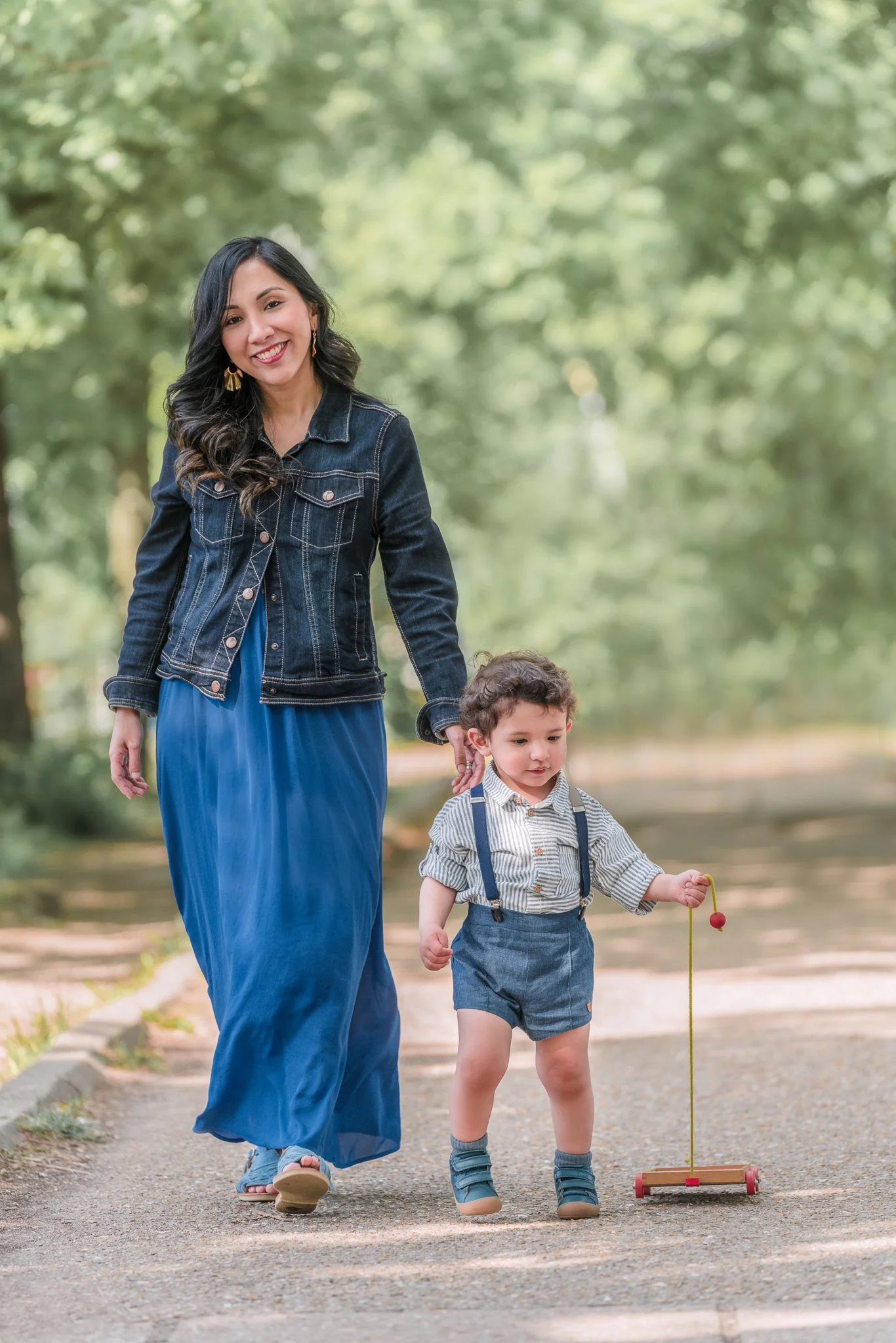 Maman élégante se promène avec son fils  qui tire une jouet dans l’allée des Cygnes à Paris 16