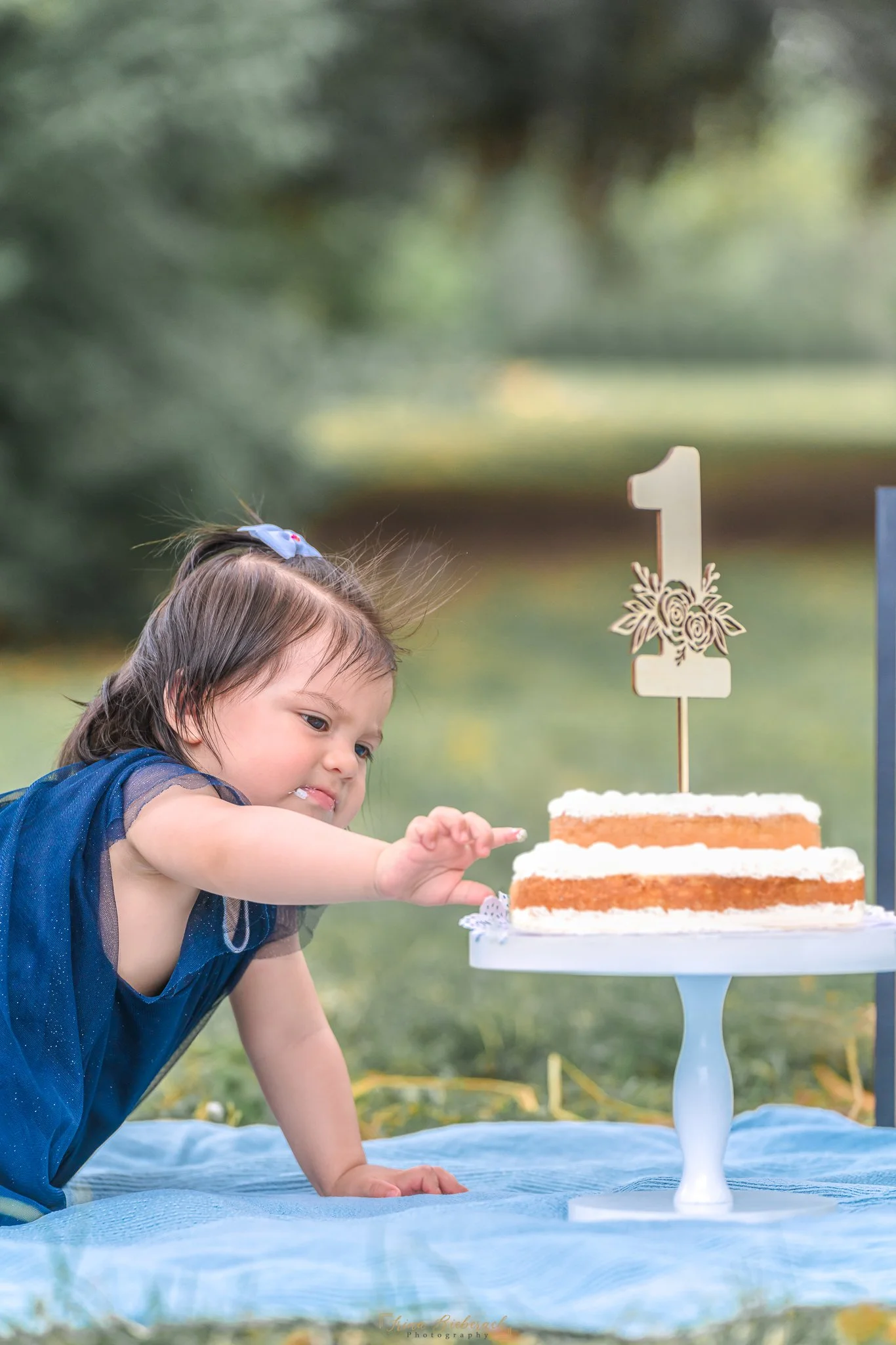 Petite fille essaye de manger un gâteau d'anniversaire d'un an