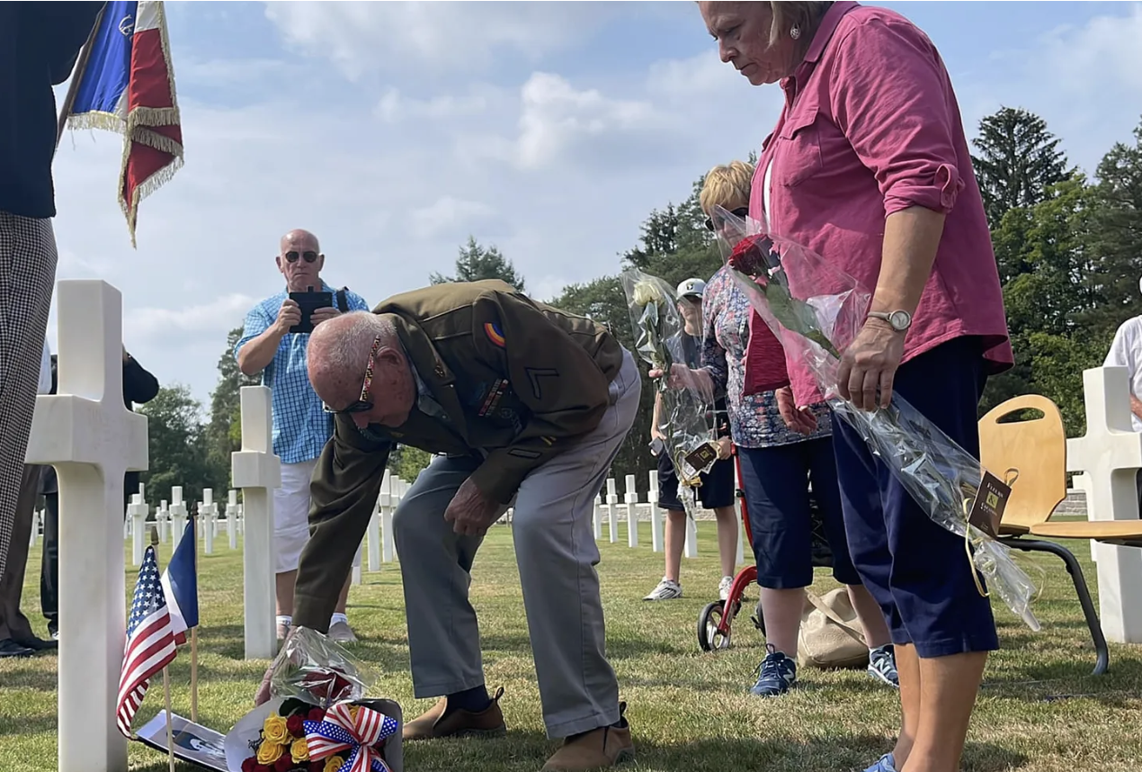 Bud Gahs and Erin Faith Allen hold a ceremony in Epinal American Cemetery to honor Wayne Cruse and Barney Parrish of the Anti-Tank Company, 222nd Infantry Regiment, 42nd 'Rainbow' Division