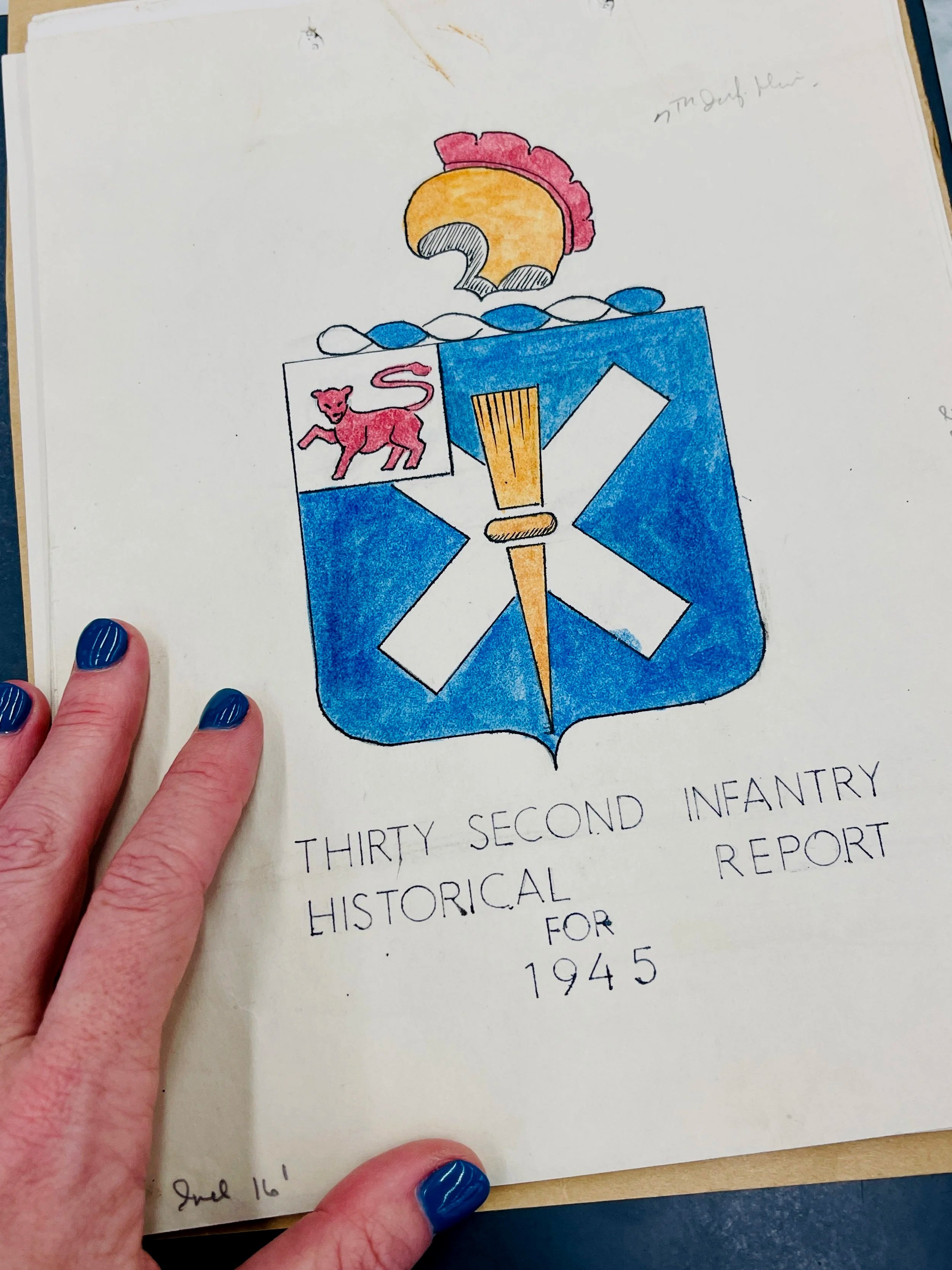 Historian Erin Faith Allen holding the 32nd Infantry Historical Report for 1945, WWII primary source archival research