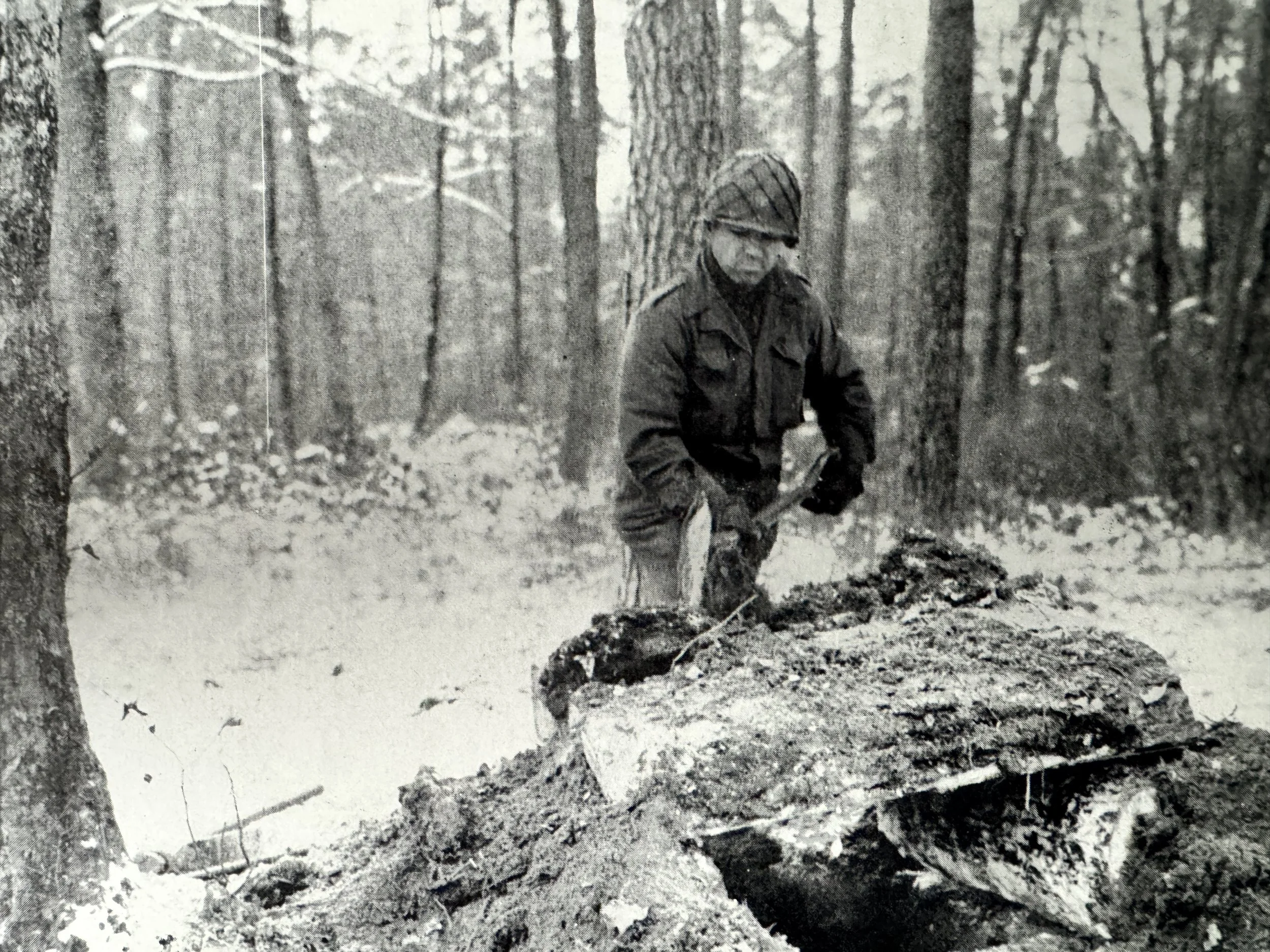 An infantryman of the 42nd Rainbow Division erects a cover over his foxhole to protect from mortar and artillery fire, Operation Nordwind, January 1945, Alsace, France.