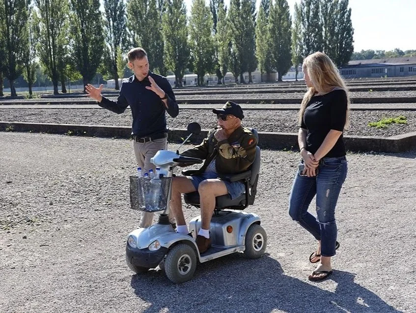 Historian Erin Faith Allen, 42nd Rainbow Division Dachau liberator Lockered Bud Gahs, and KZ-Gedenkstätte Dachau staff member Alex Pearman on the memorial grounds, August 2022