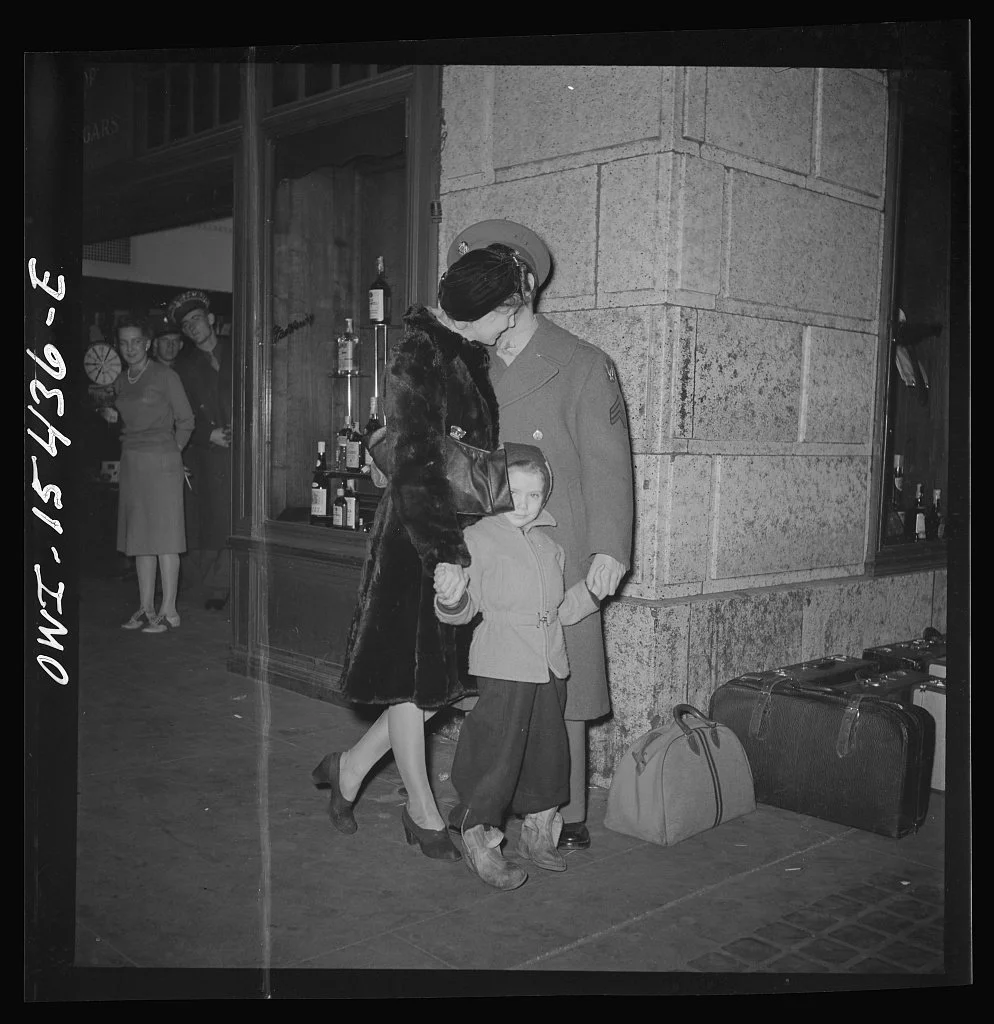 A Soldier and his wife and daughter wait at a train station in Chicago during WWII