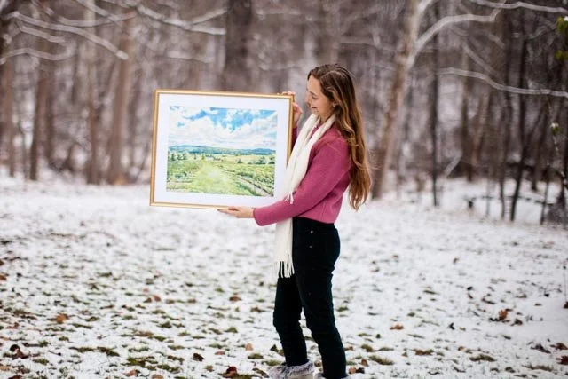 Eva Kay Mckinley holding artwork