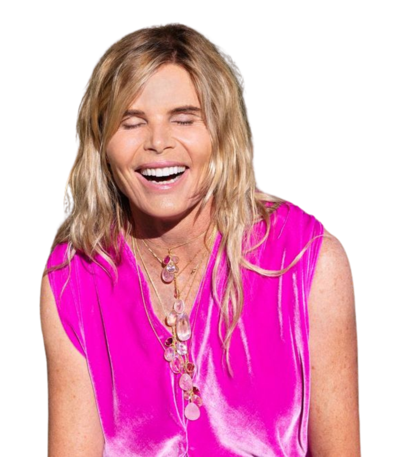 Woman with long blonde hair wearing pink satin sleeveless top and layered pink jewelry, smiling with eyes closed.